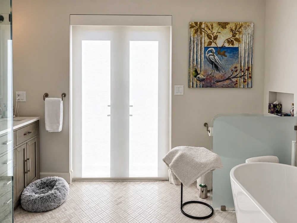 Light-filtering roller shade covering glass bathroom doors