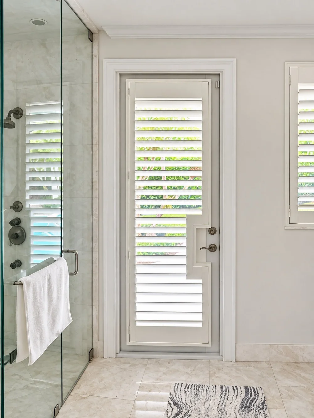Plantation shutter panel on a glazed bathroom door with clearance around its handle