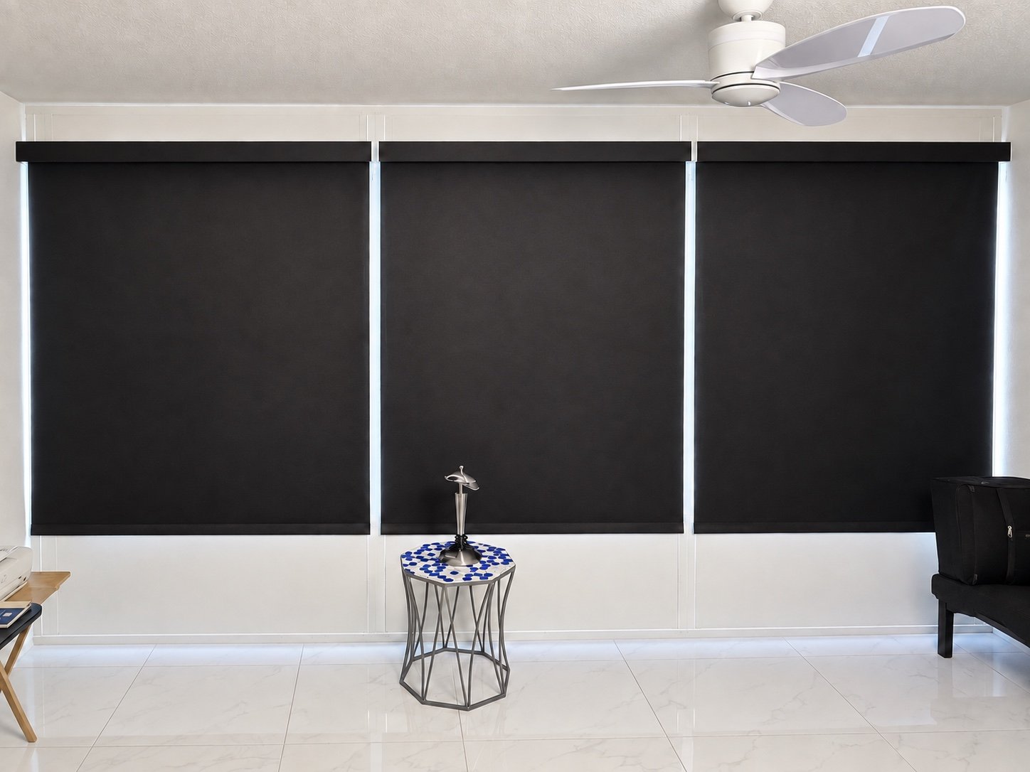 Three dark roller shades fitted across a wide bank of windows