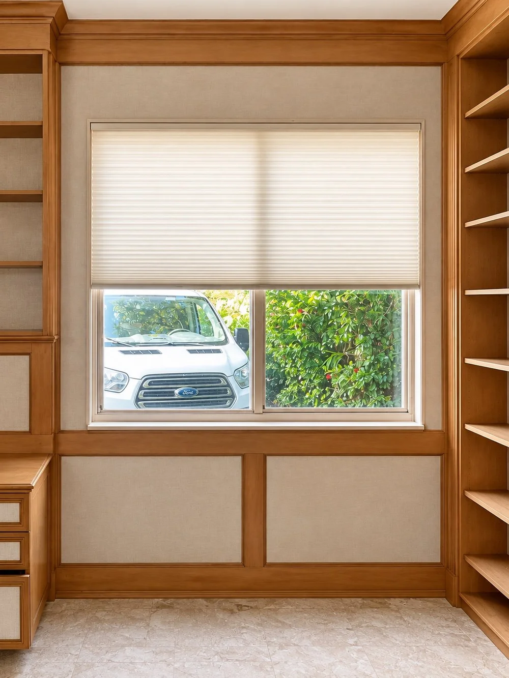 White cellular shade fitted inside a window in a wood-paneled room