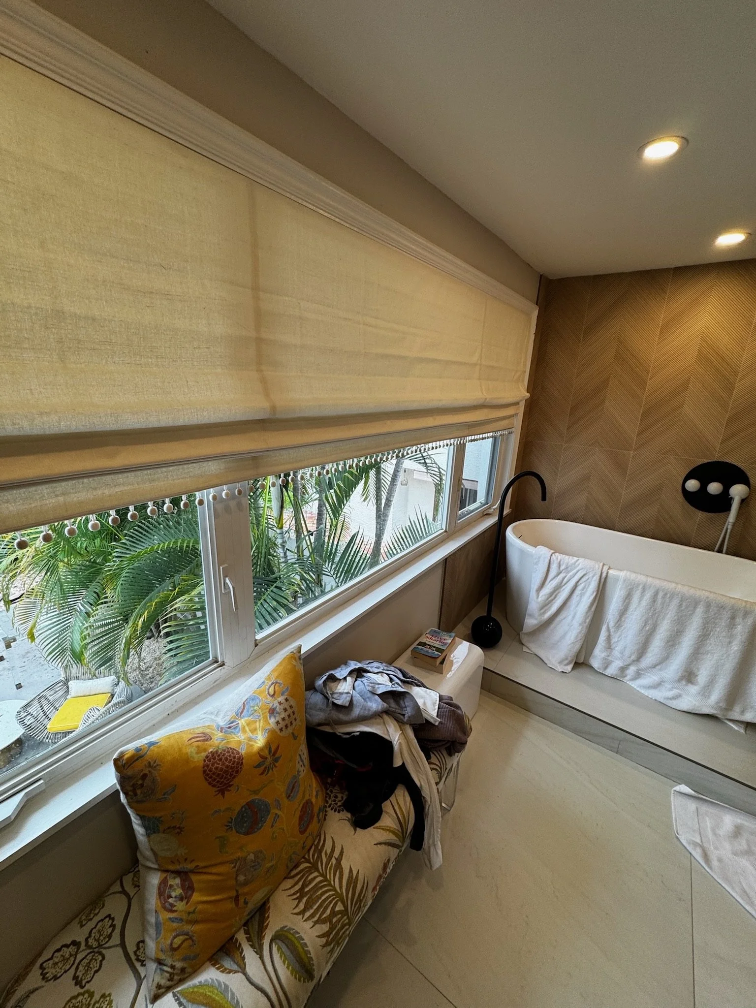 Wide Roman shades above a built-in window seat.