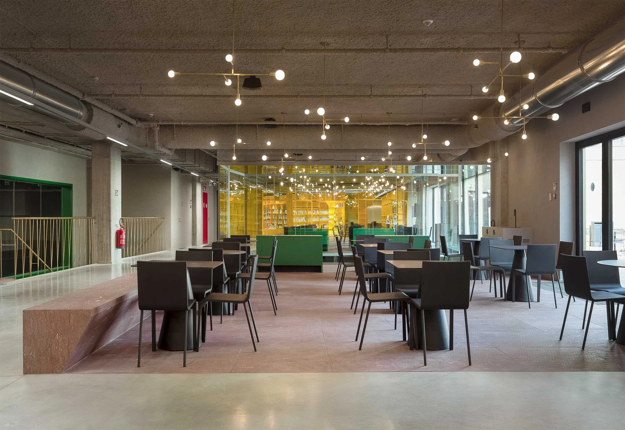 Interior view of the restaurant bar at Kunstencentrum in Aalter, showcasing minimalistic design with modern chairs, simple tables, elegant lighting