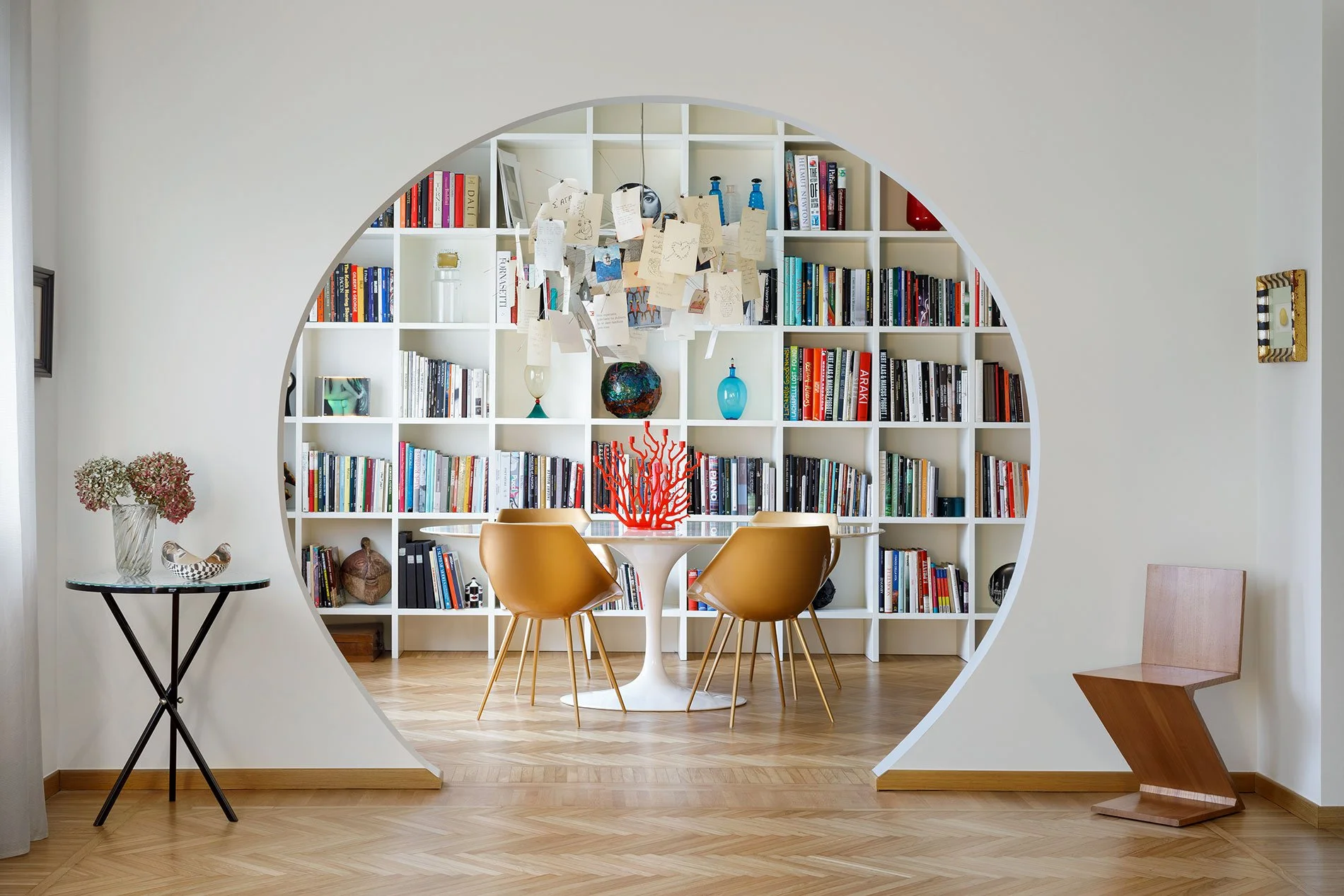 Dettaglio architettonico dell’apertura circolare che incornicia la zona libreria in un appartamento contemporaneo a Milano