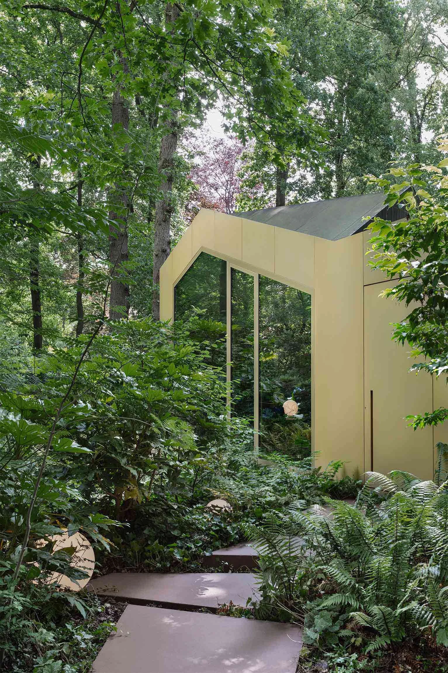 Photo of the entrance of a former chalet renovated into a house in a forest.