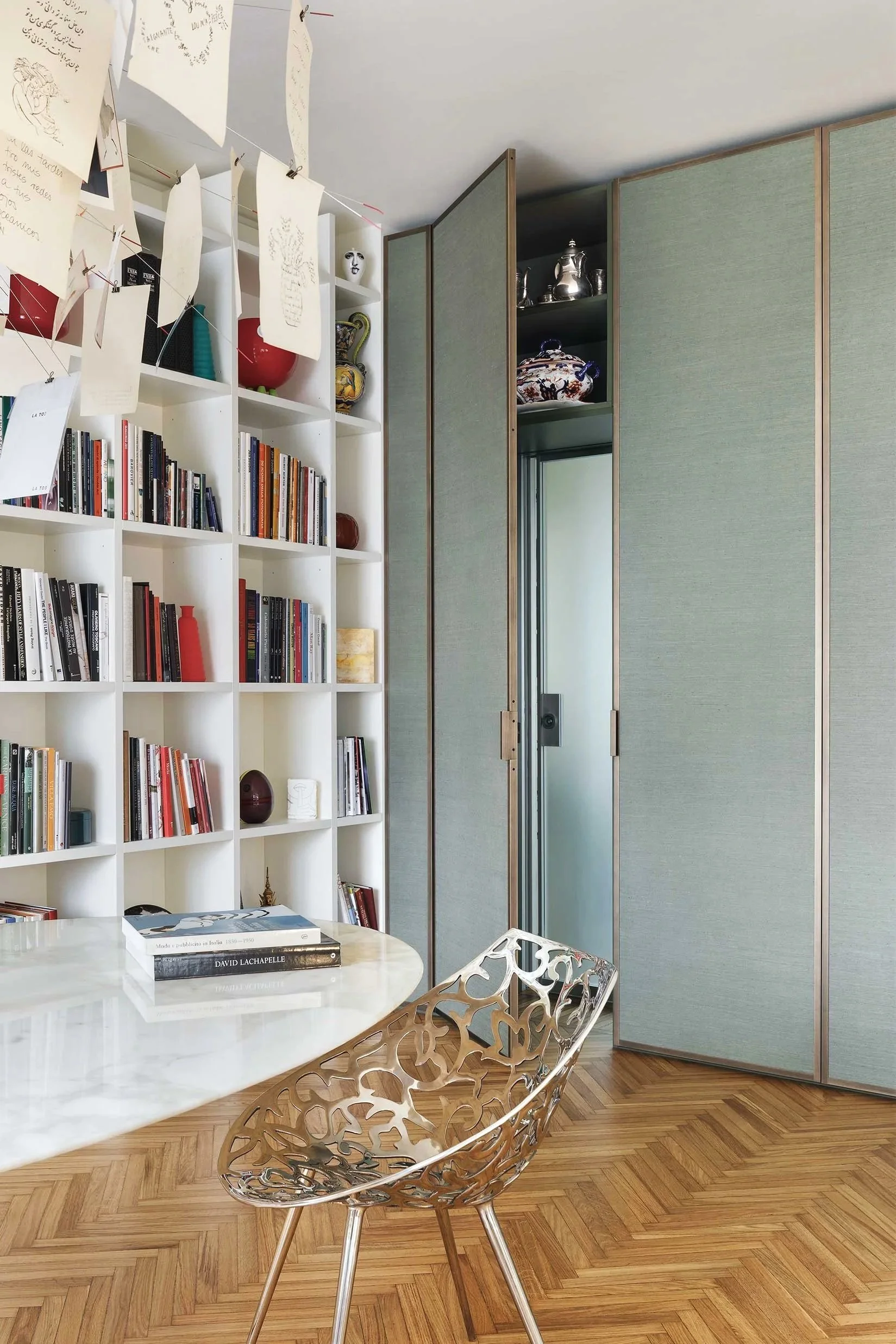 Studio dal design contemporaneo in un appartamento milanese ristrutturato, caratterizzato da libreria a tutta parete, armadio con pannelli tessili