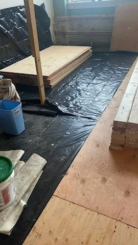 Ram board was removed and a continuous vapor barrier was installed over the original mill floor prior to installing the new subfloor.