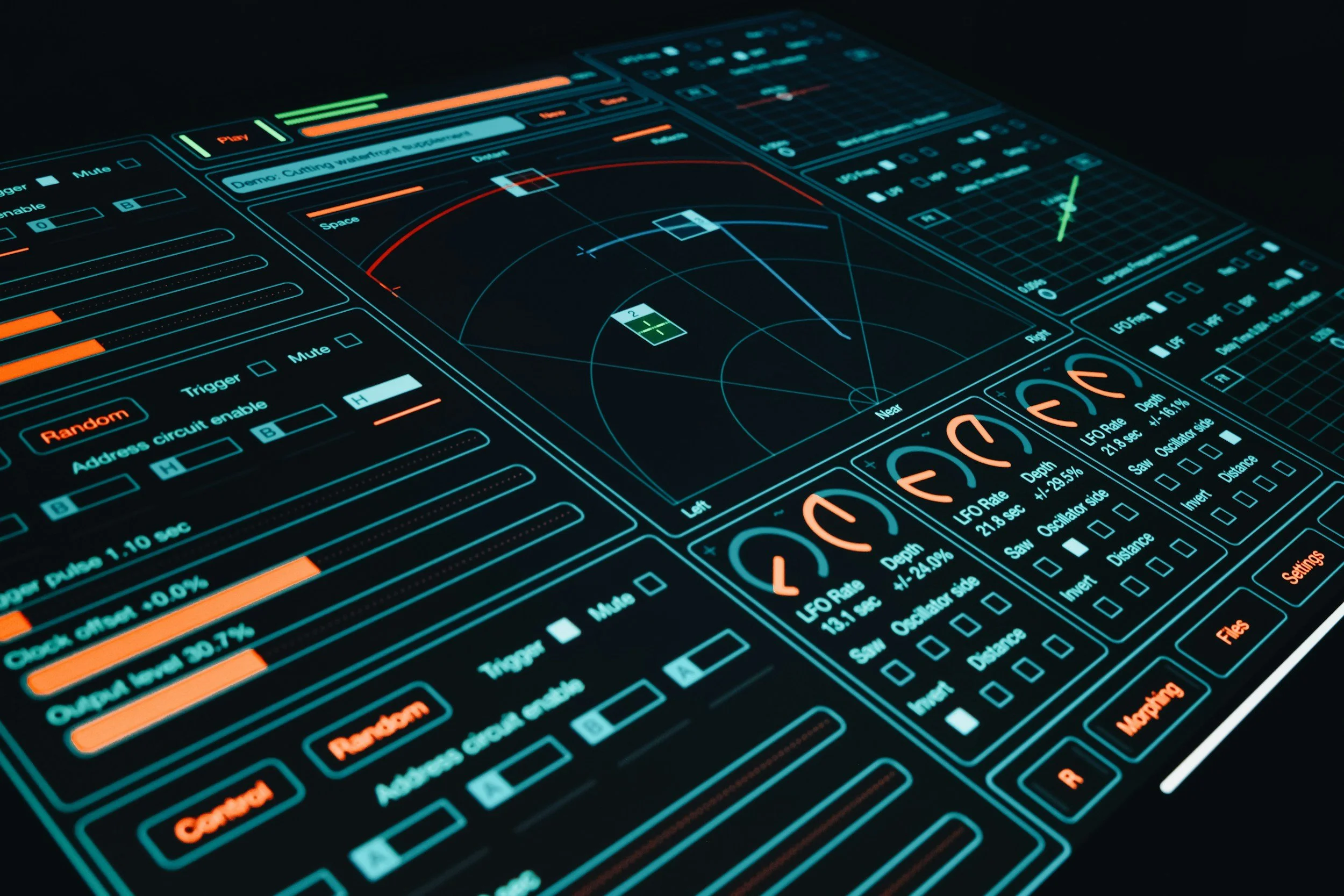 Futuristic digital control panel with various graphs, gauges, and controls illuminated in blue, green, orange, and red on a dark background.