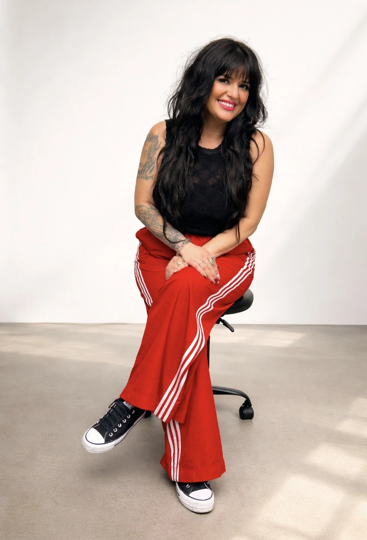 Woman with long black hair wearing a black shirt and turquoise pendant necklace.