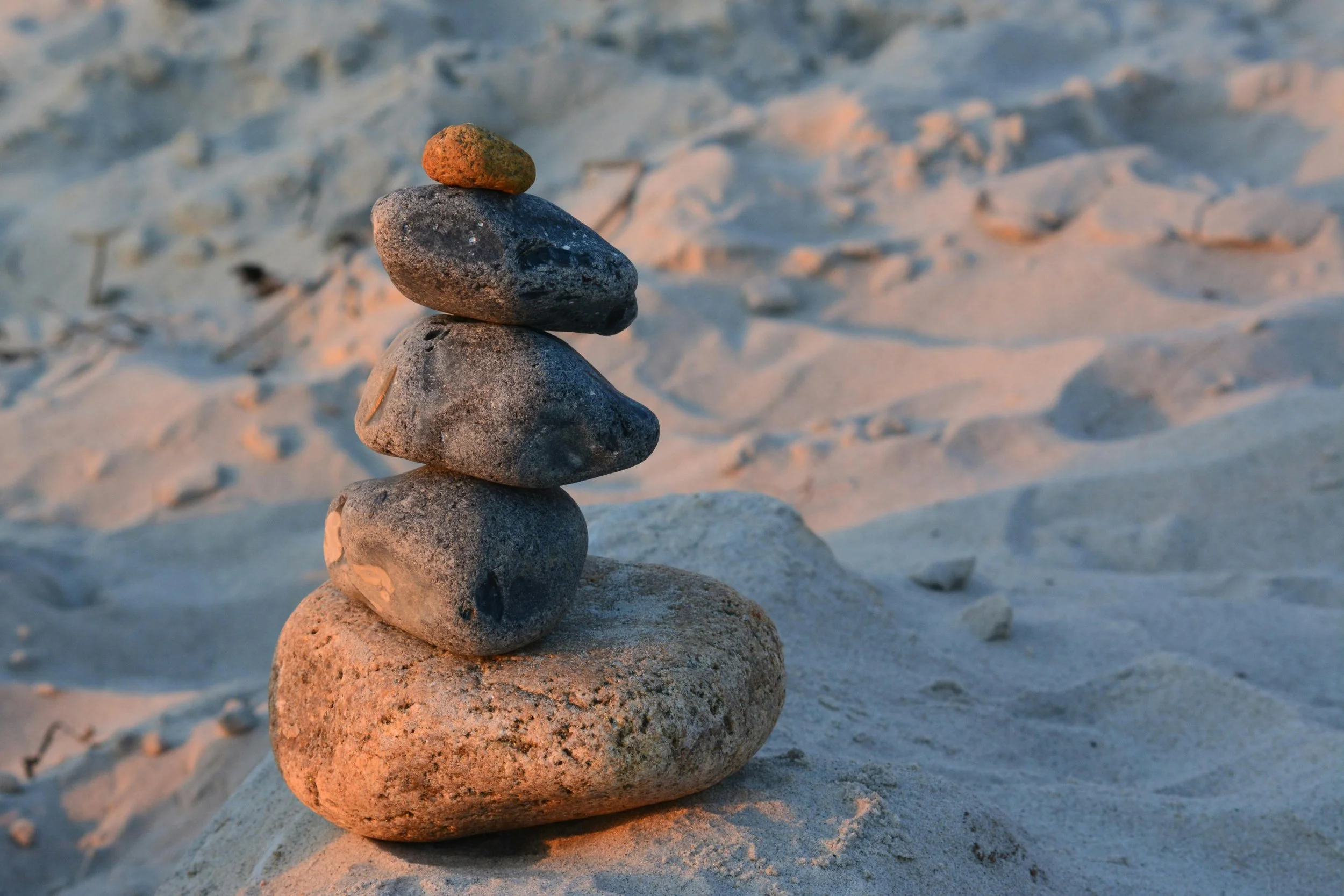 Stacked stones on sand in a balanced arrangement