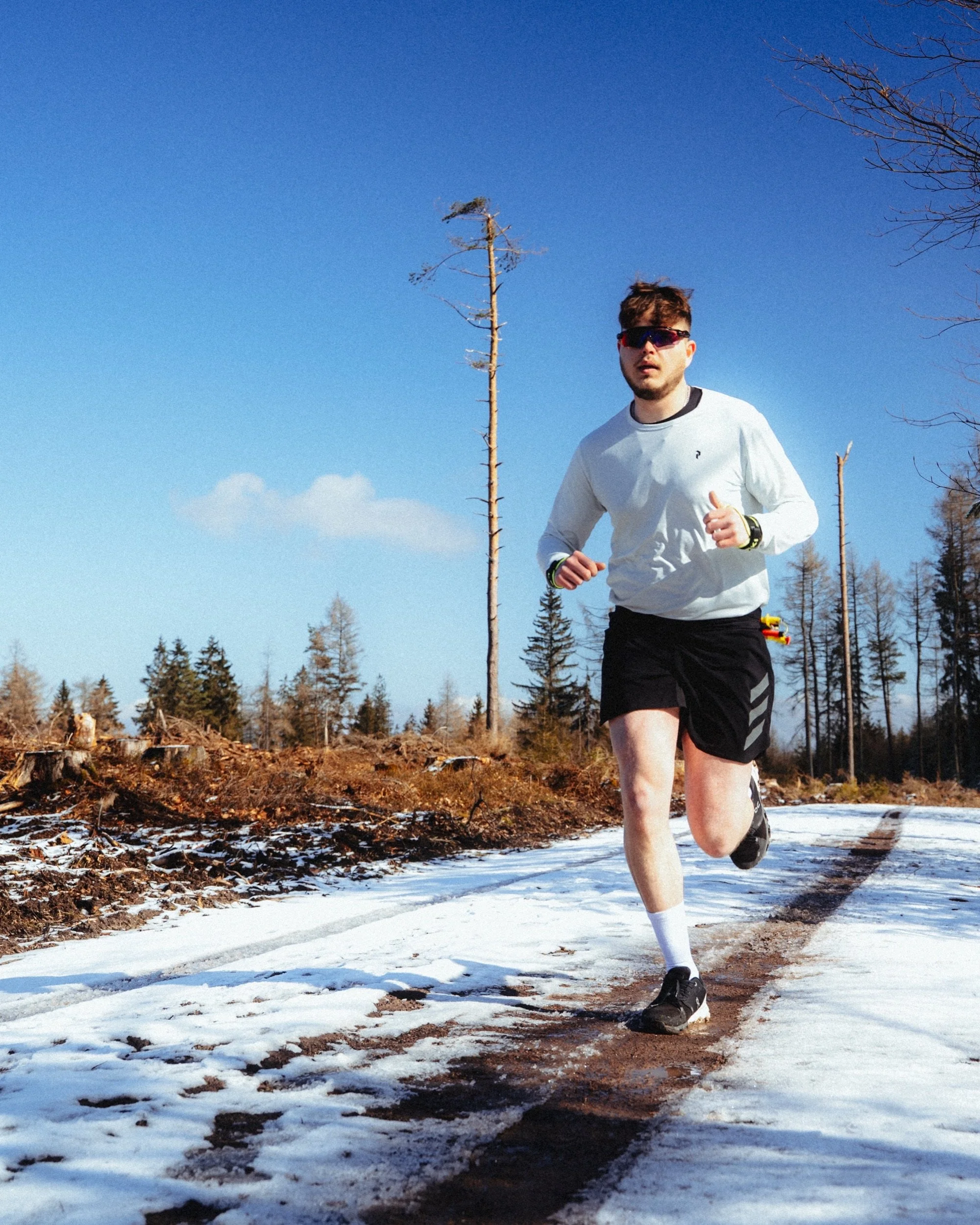 Trail runner in Adidas Terrex on a snowy path under a blue sky, Thuringian Forest, Germany