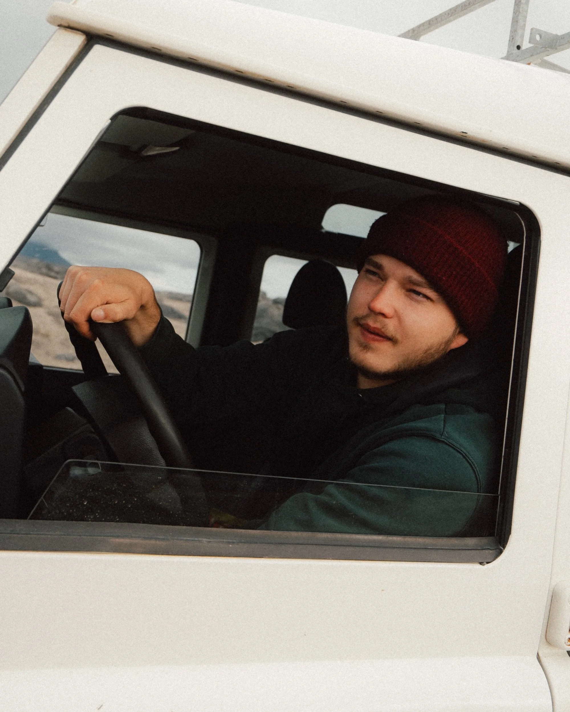 Portrait of the driver in a red beanie, Land Rover Defender road trip through the Icelandic Highlands