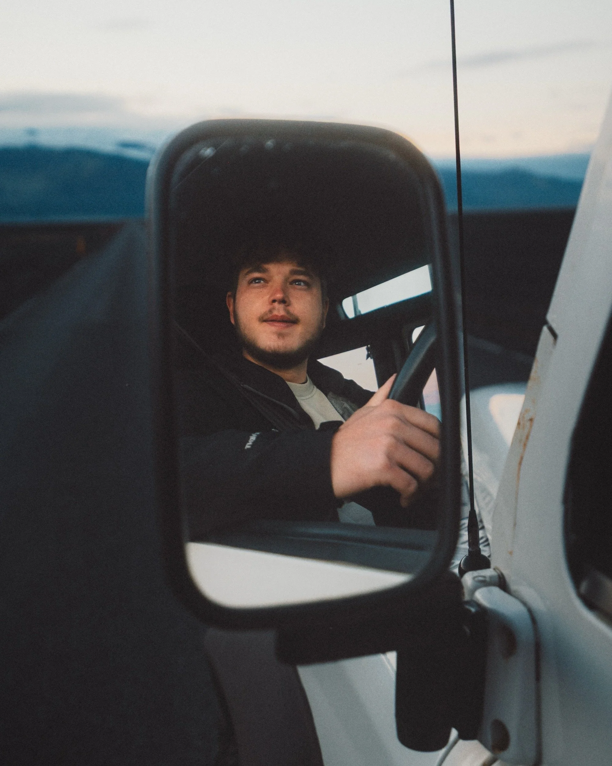 Portrait in the side mirror of a Land Rover Defender, Icelandic landscape reflected