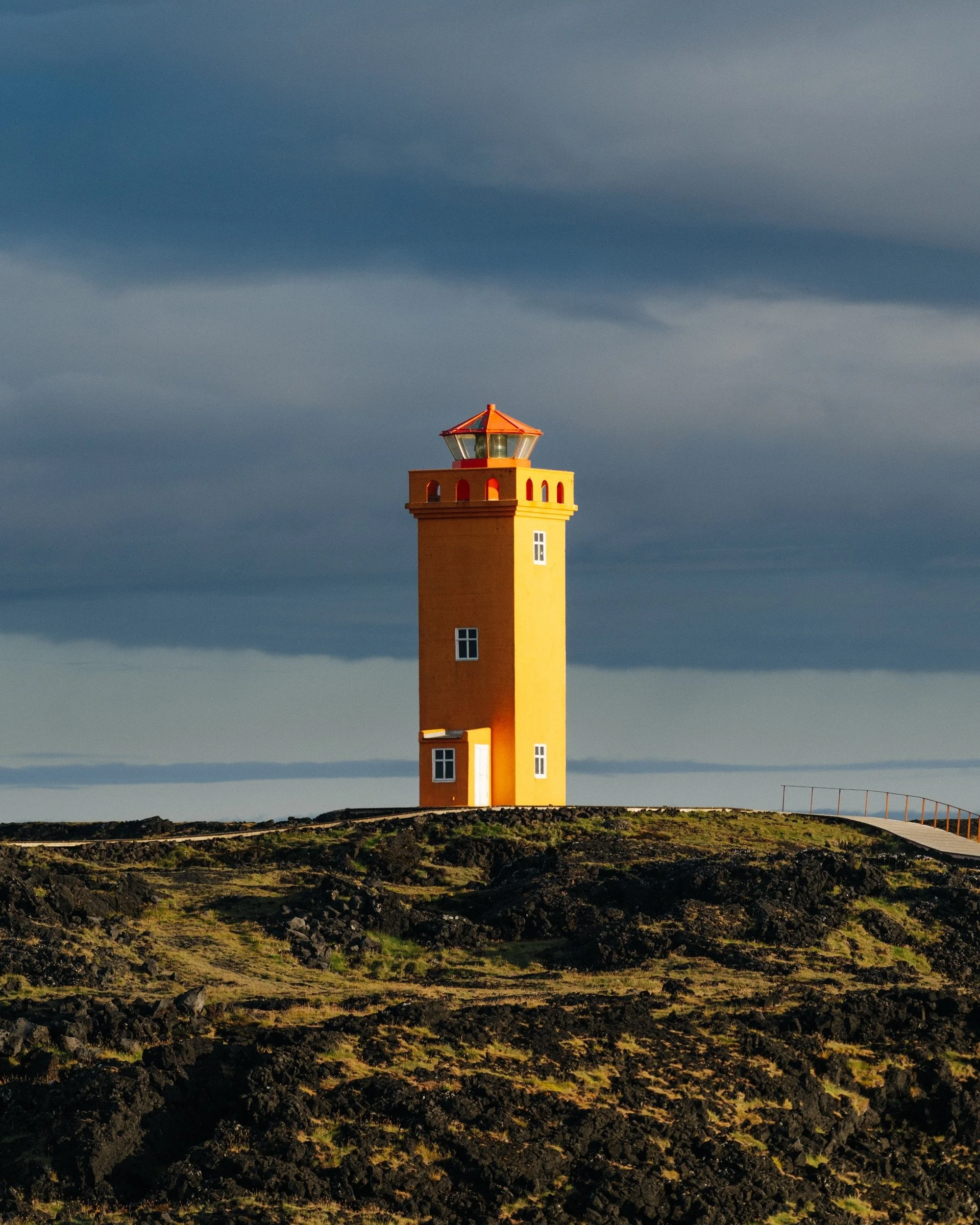 Yellow lighthouse on black volcanic rock, Iceland