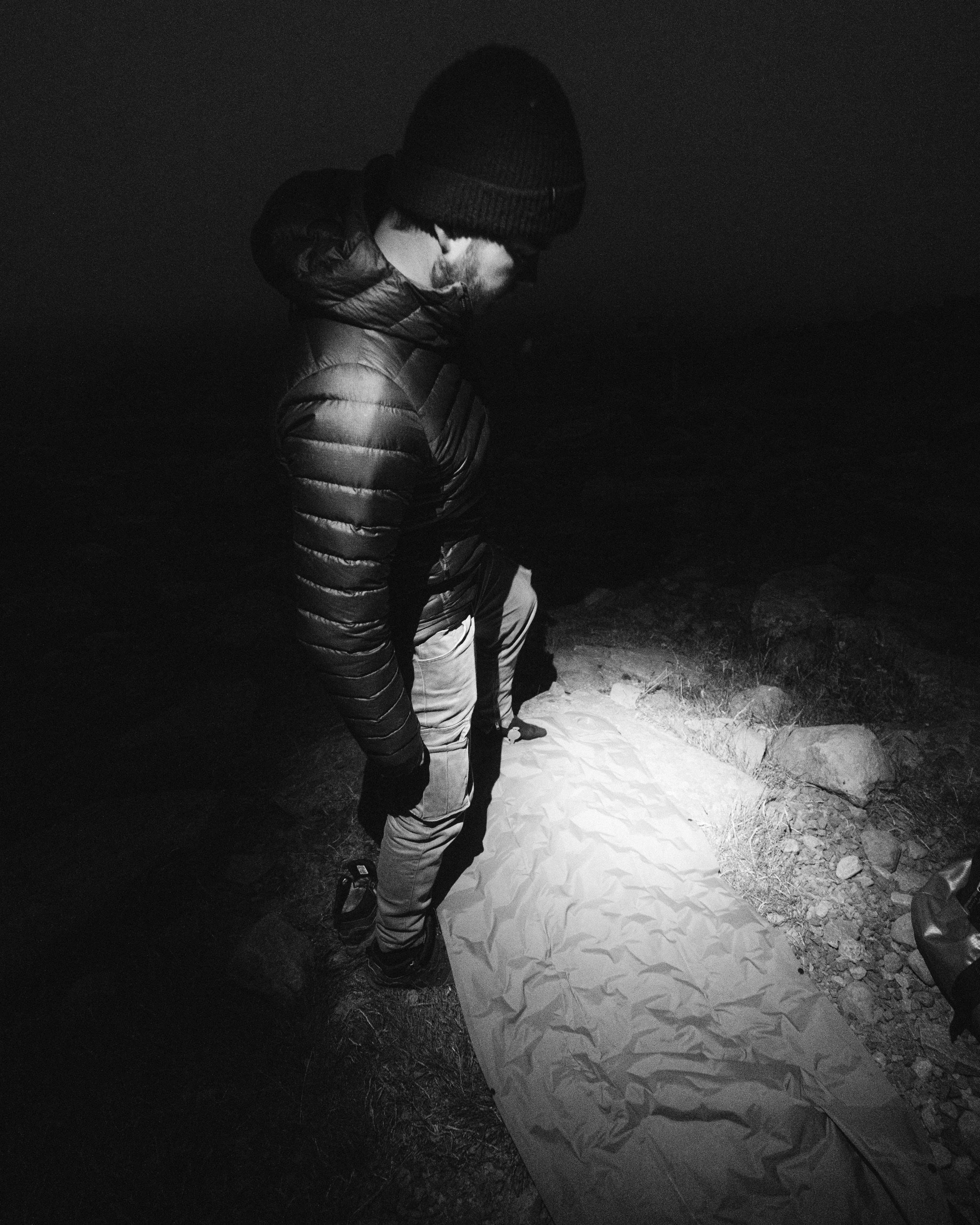 Inflating a sleeping mat at night after a long day in the Icelandic Highlands, flash photography
