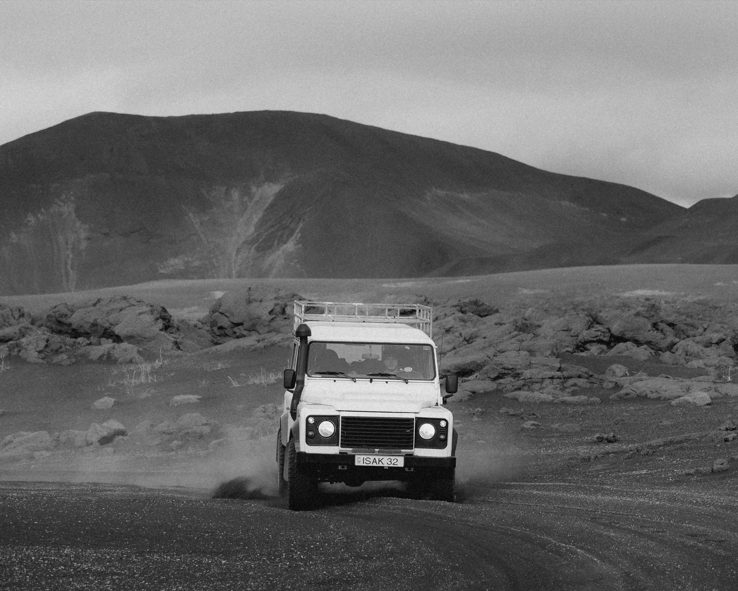 Drifting Land Rover Defender on a gravel road through the Highlands, black and white, Iceland