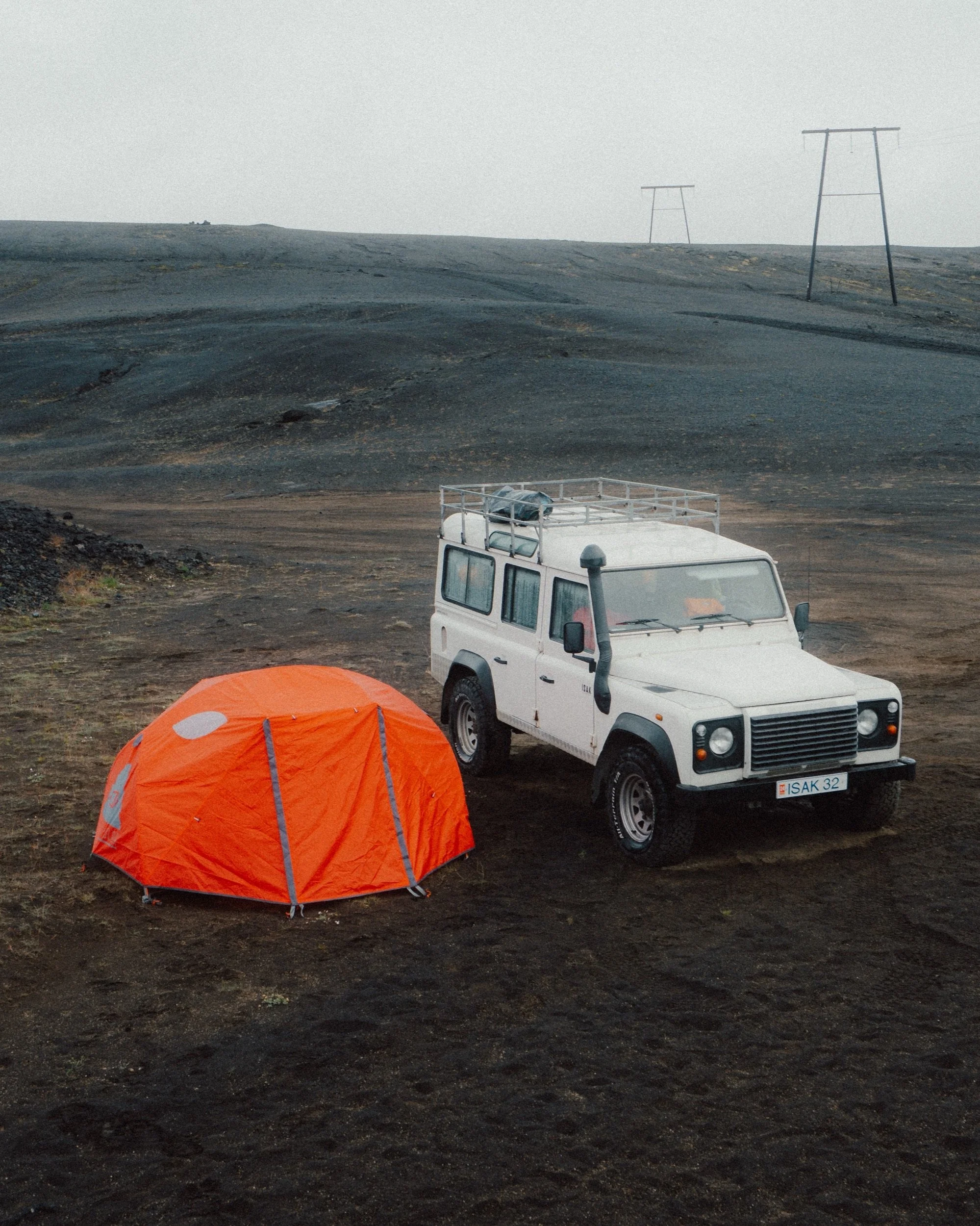 Land Rover Defender and poler tent on black volcanic sand in the Icelandic Highlands