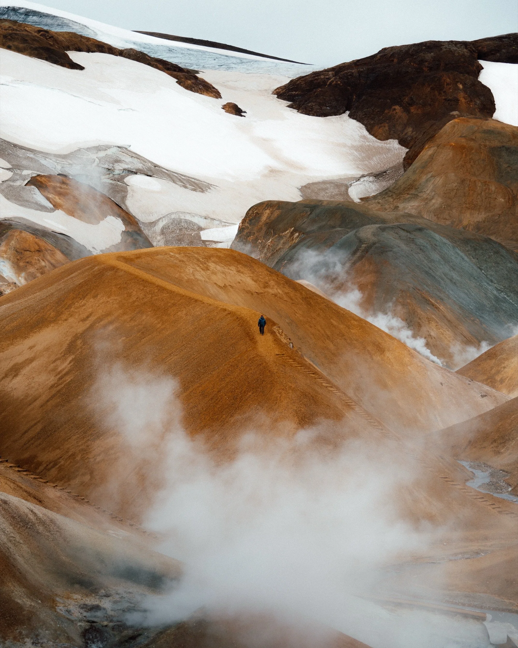 Hiker in the geothermal area of Kerlingarfjöll with rising steam, Icelandic Highlands