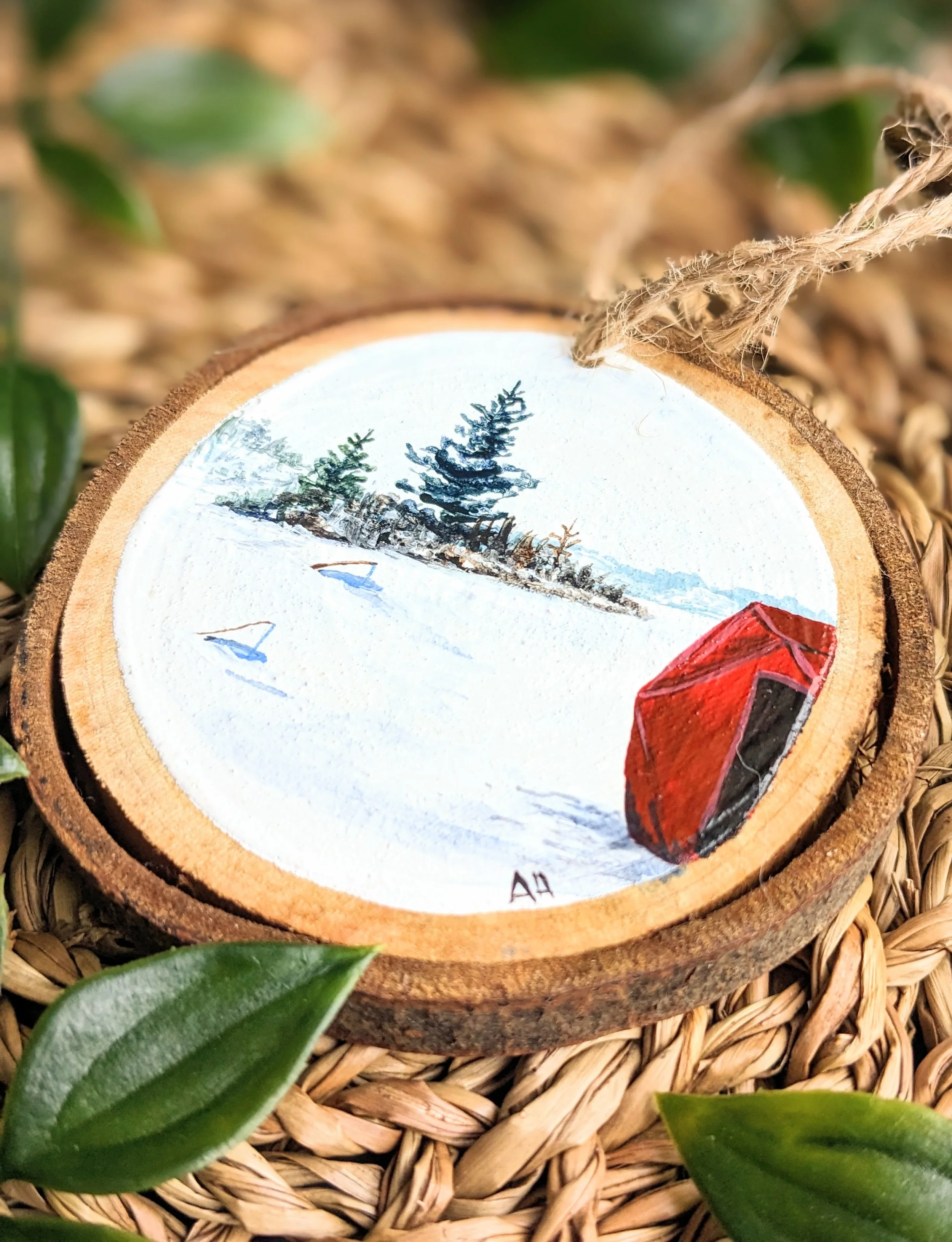 Custom hand-painted Christmas ornament featuring an ice hut on a frozen lake (2022)