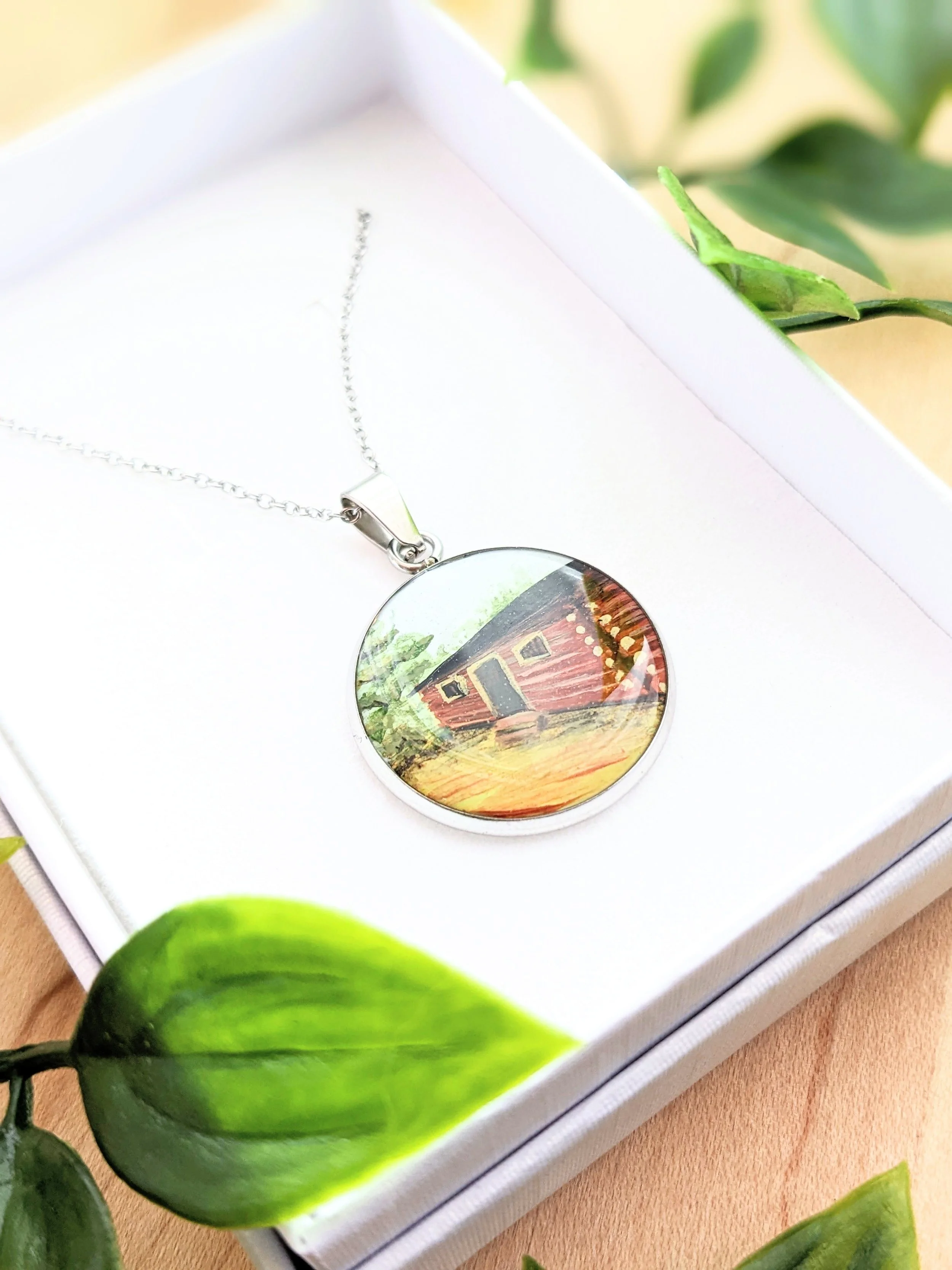 Custom hand-painted necklace featuring a log cabin (2022)