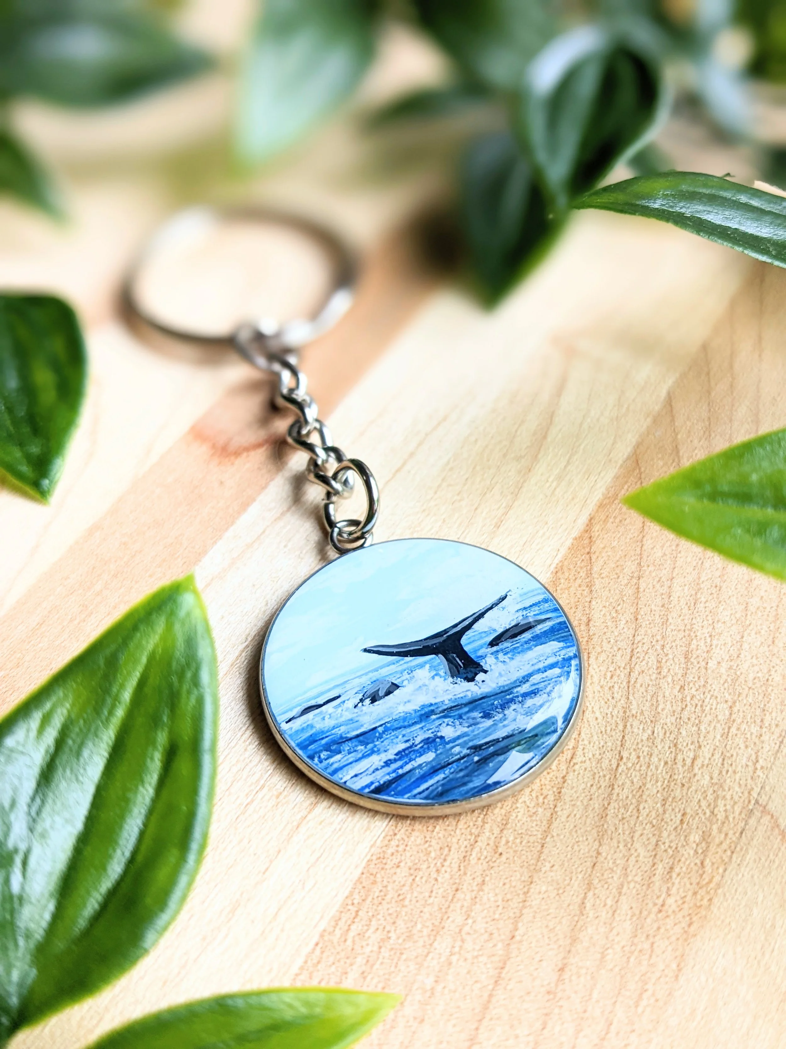 Custom hand-painted keychain featuring an ocean and a whale tail (2022)