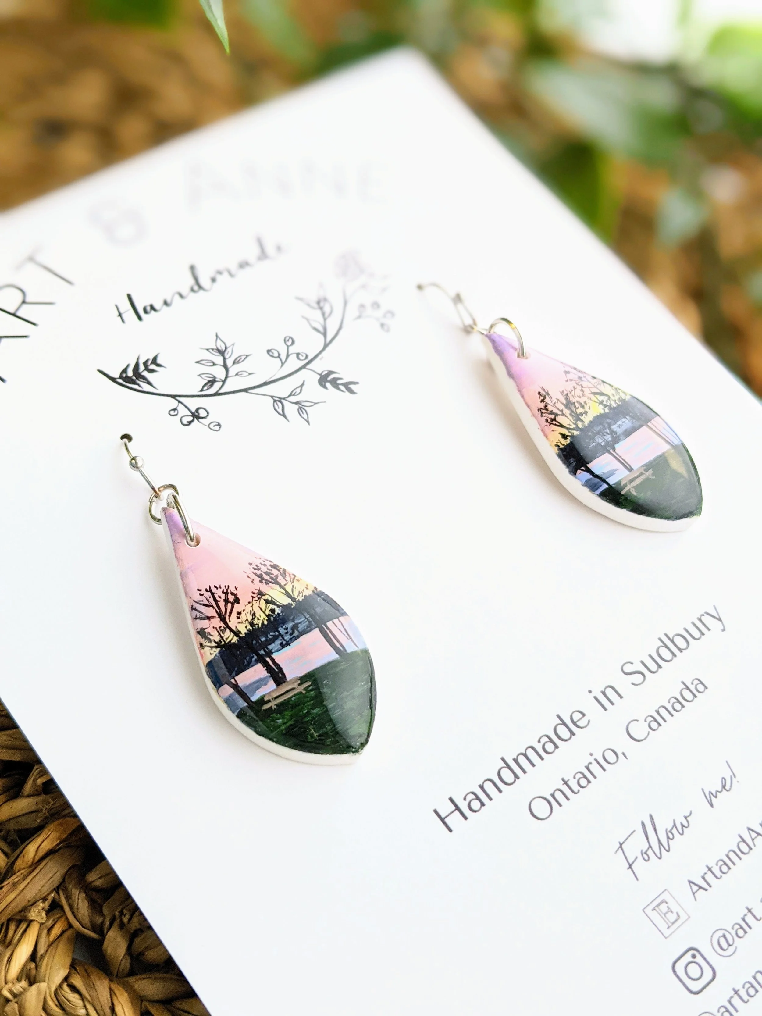 Custom hand-painted teardrop earrings featuring a backyard view along a lake (2022)