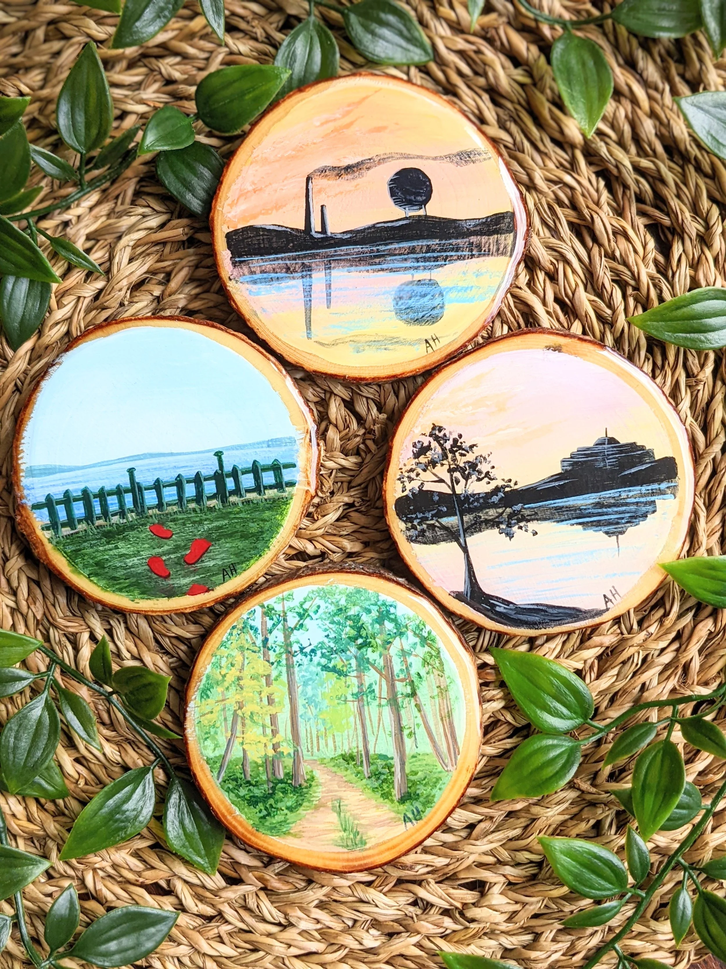 A set of four hand-painted coasters featuring the Sudbury smokestack and Big Nickel, Science North, and a forest (2022)