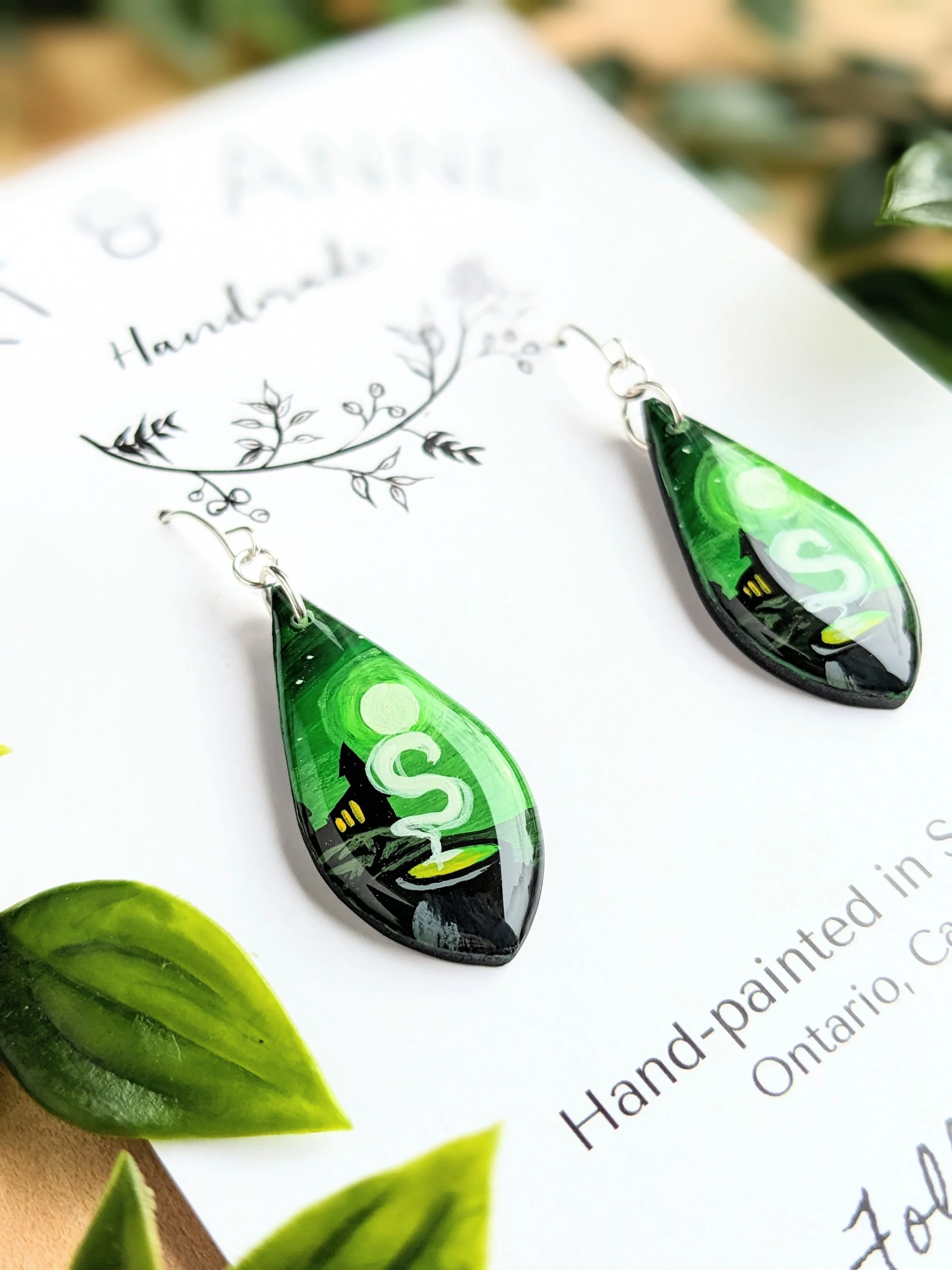 Custom hand-painted teardrop earrings featuring the artists own depiction of a famous wizarding world (2023)