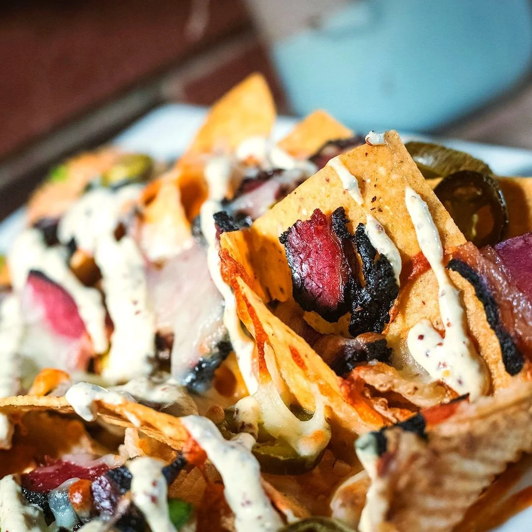 File these pastrami nachos under things you didn't know you needed until right this moment.⁠
⁠
Shaved beef pastrami, peppers, onions, cheddar &amp; jack cheese, pickled jalape&ntilde;os, Dijon mustard crema, mix of corn chips &amp; potato chips⁠
⁠
Li