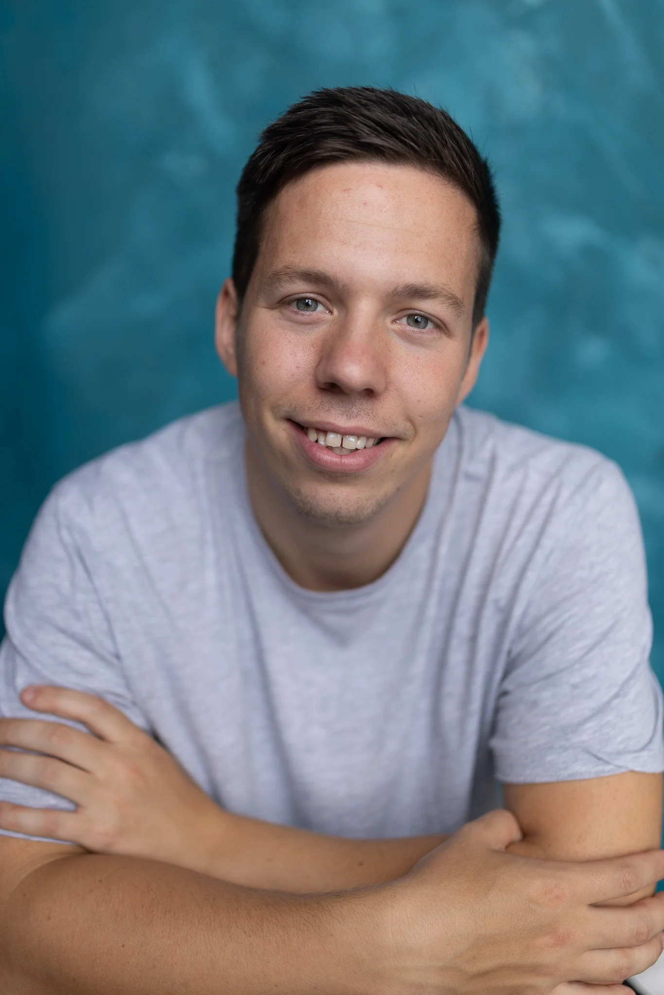Actor photograph headshot of a Brownhaired man with blue eyes on a blue background