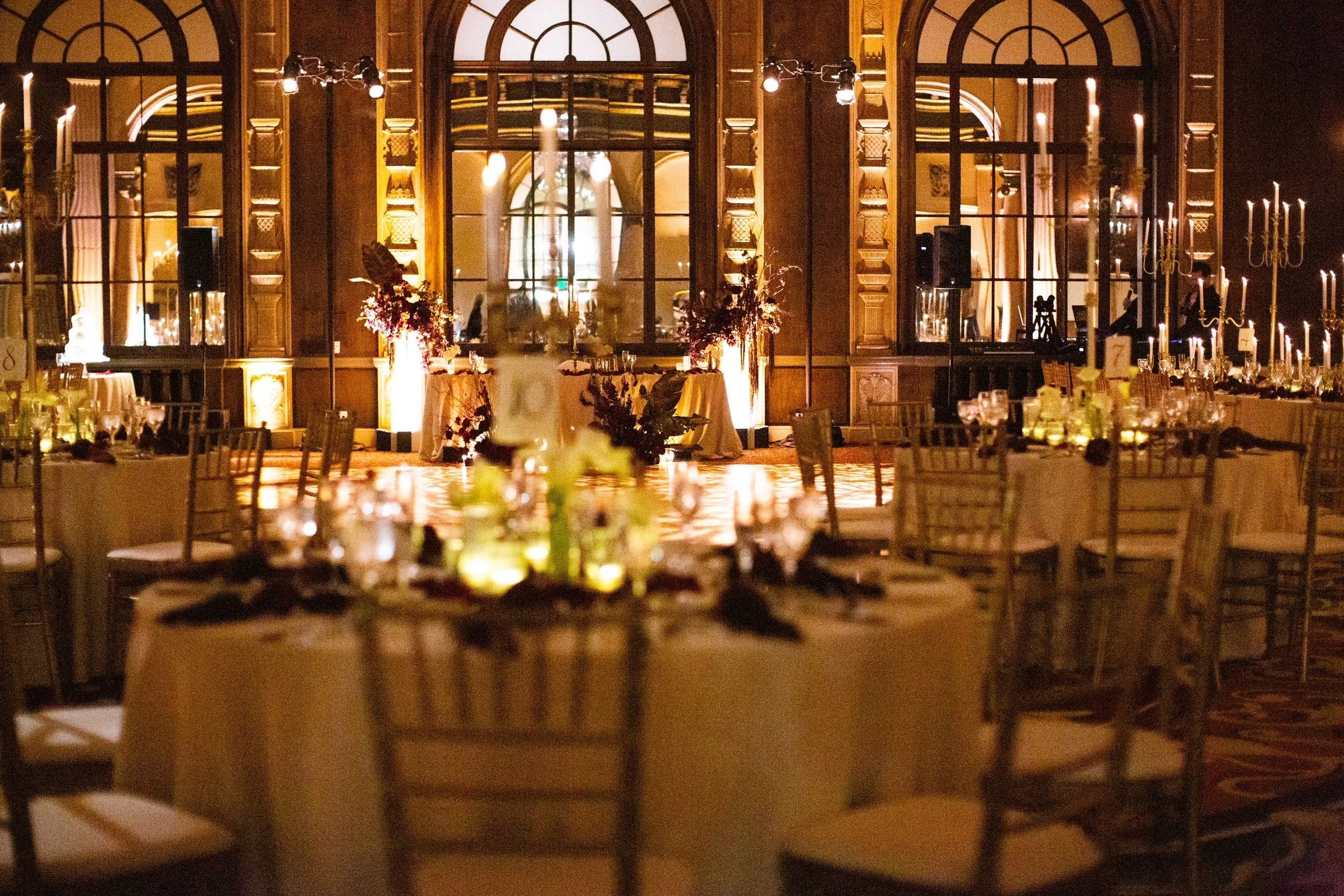 The reception space is elegantly arranged with gold-accented décor, plush seating, and dramatic lighting that enhances the timeless Hollywood ambiance.