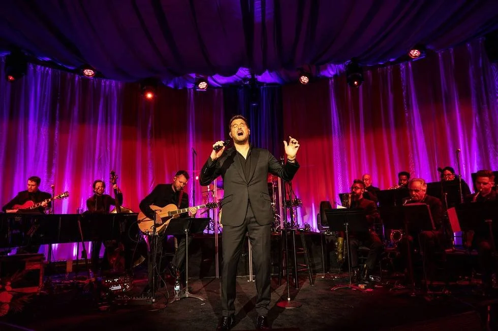 A candid moment featuring Michael Bublé performing or interacting with the crowd in the event space.