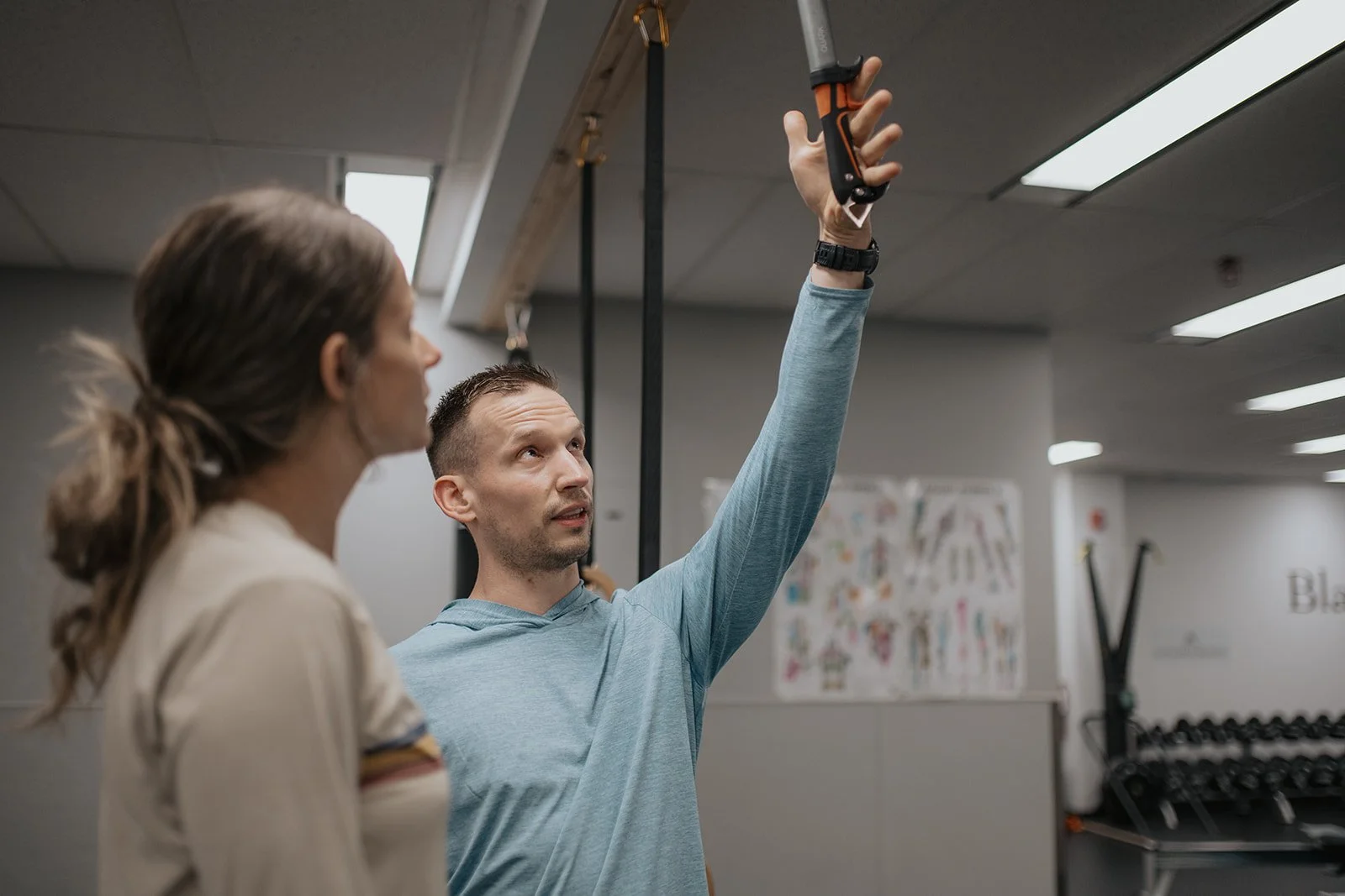 personal fitness trainer demonstrating exercise with ice climbing gear
