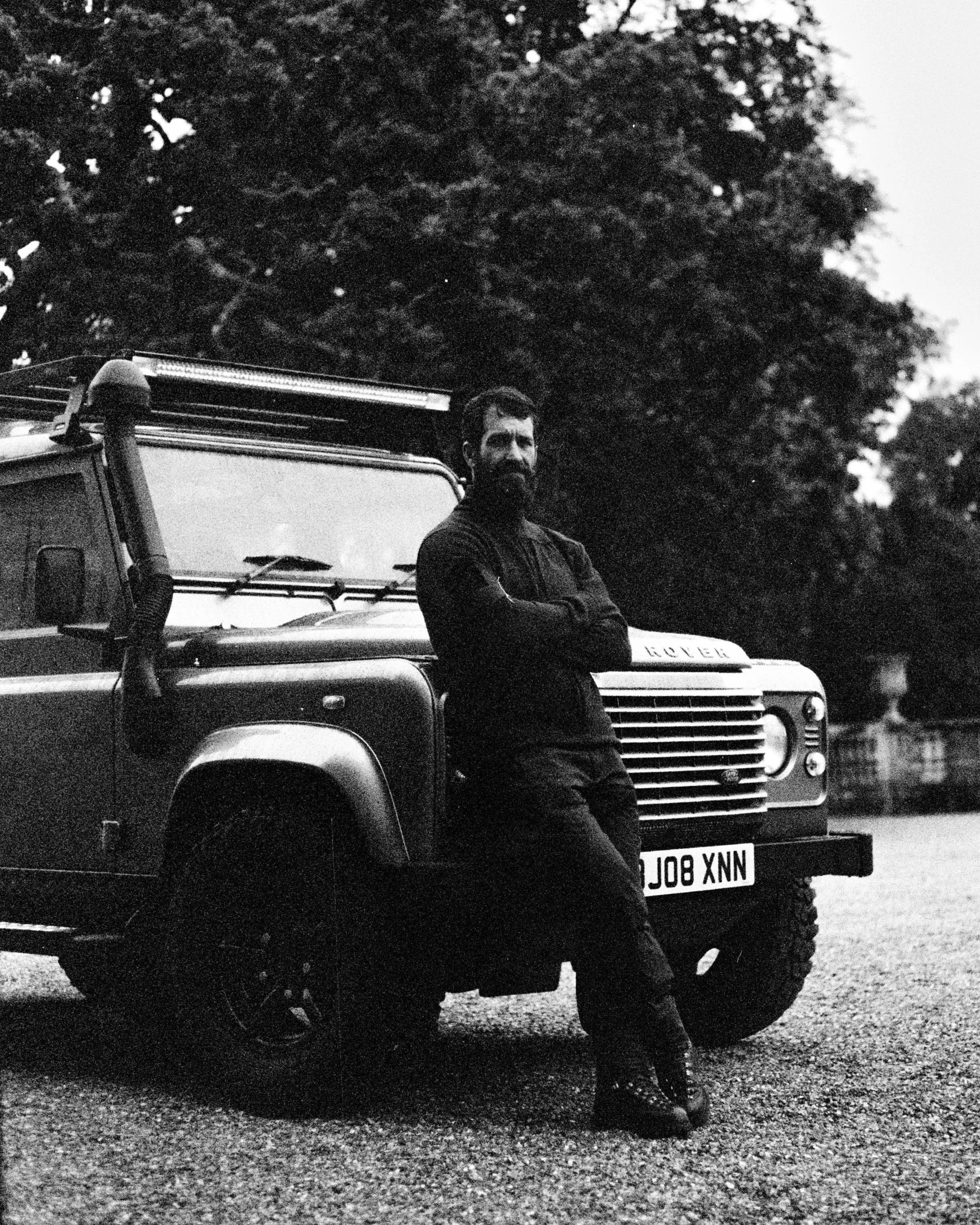 male standing against his vintage classic landrover in the countryside. lifestyle brand photographer hp5 35mm film