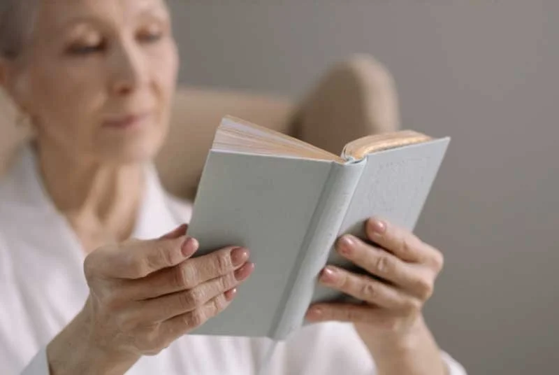 Elderly woman reading in her 70s, improved cognitive function after HBOT