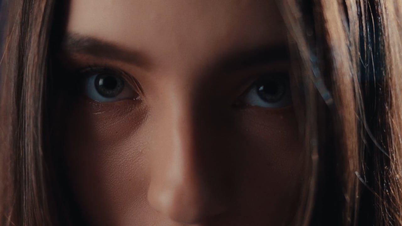 Close-up of a woman's face focusing on her eyes and part of her nose, with brown hair framing her face.