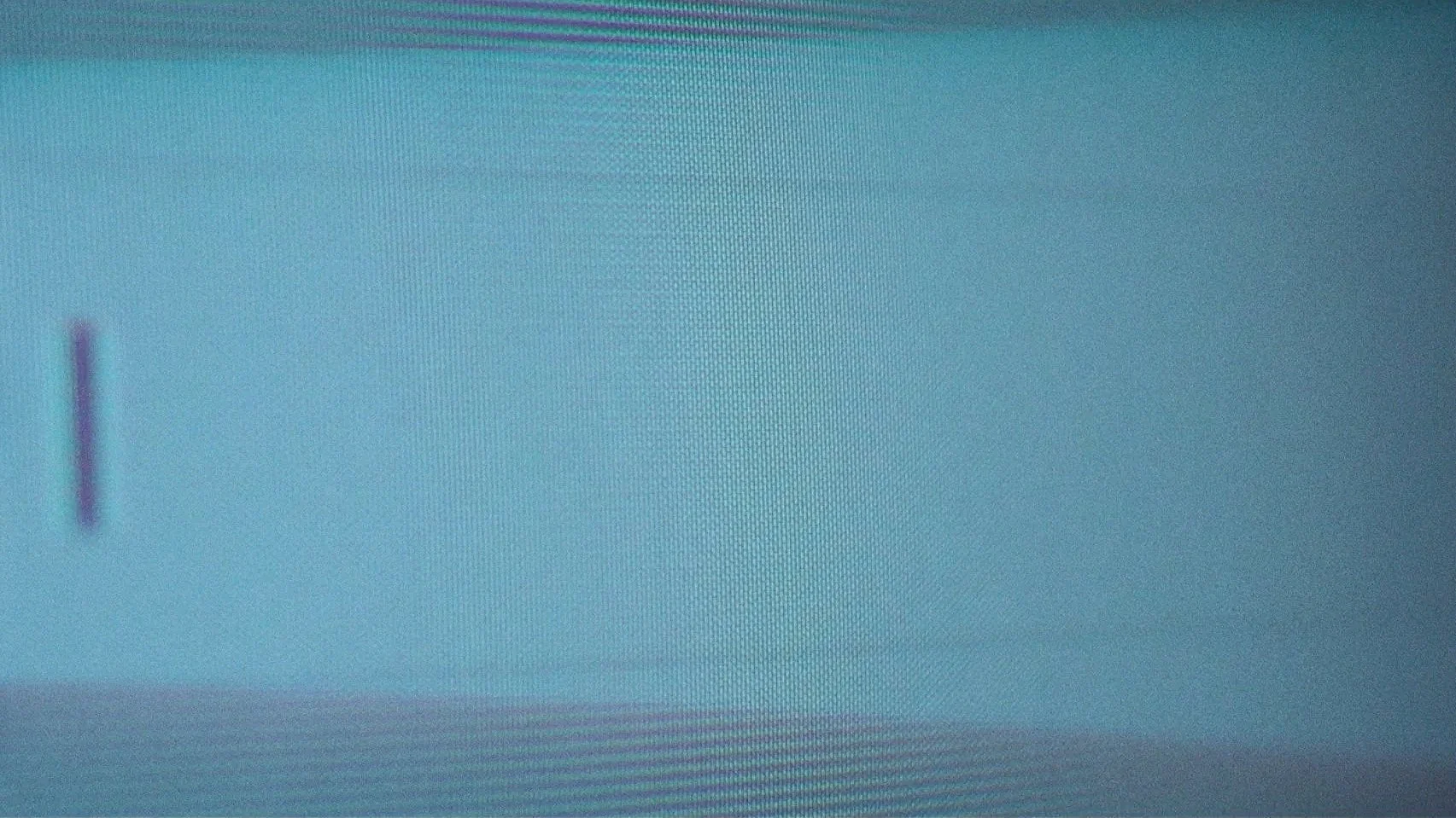 Close-up of a digital screen with a small, blurred logo or icon on the left side, and a textured, cyan background.