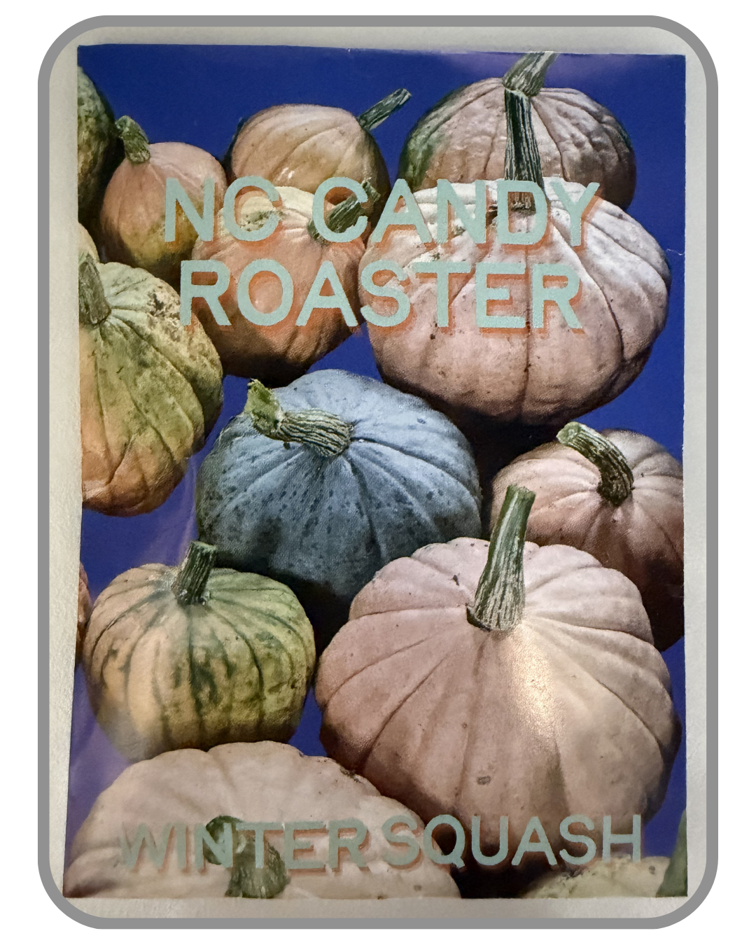 A collection of twelve heirloom seed packet images featuring vegetables grown by farmers and seed stewards in Western North Carolina. Each packet displays a close-up photograph of the crop variety and its name. The varieties include Blue Goose Southe