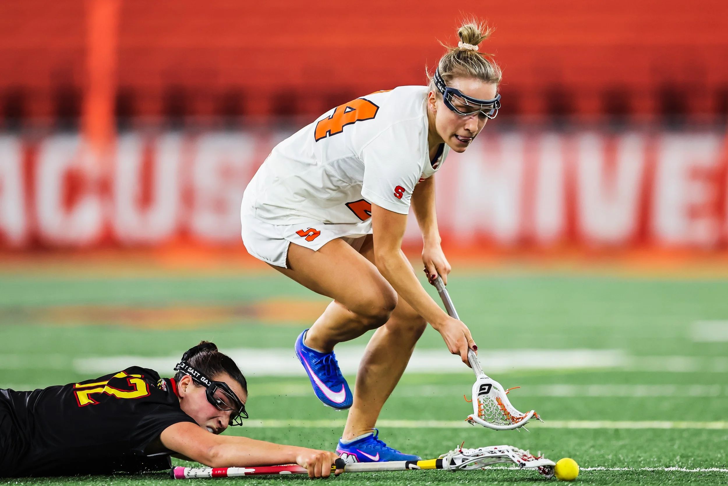 Syracuse midfielder Caroline Trinkaus (24) battles Maryland' s Annabelle Schafer (12) for possession of the ball during a lacrosse game on Feb. 6, 2026, in Syracuse, N.Y.