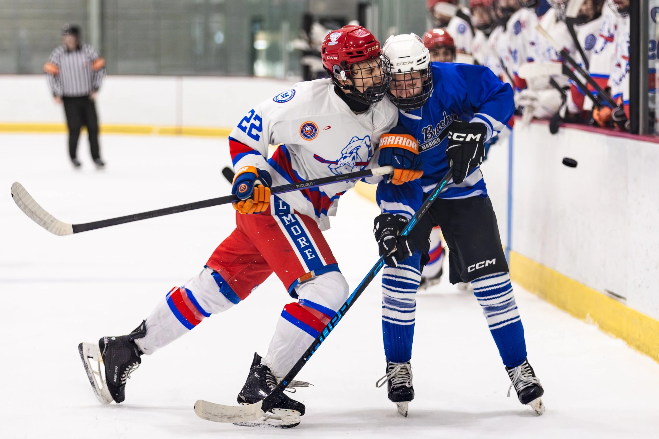 Lucas Lucchi (22) of the Bellmore-Merrick Bulldogs checks a Long Beach Mariners player during the USA Hockey state tournament semifinal at SUNY Broome Ice Center on Sunday, March 1, 2026, in Binghamton, N.Y.