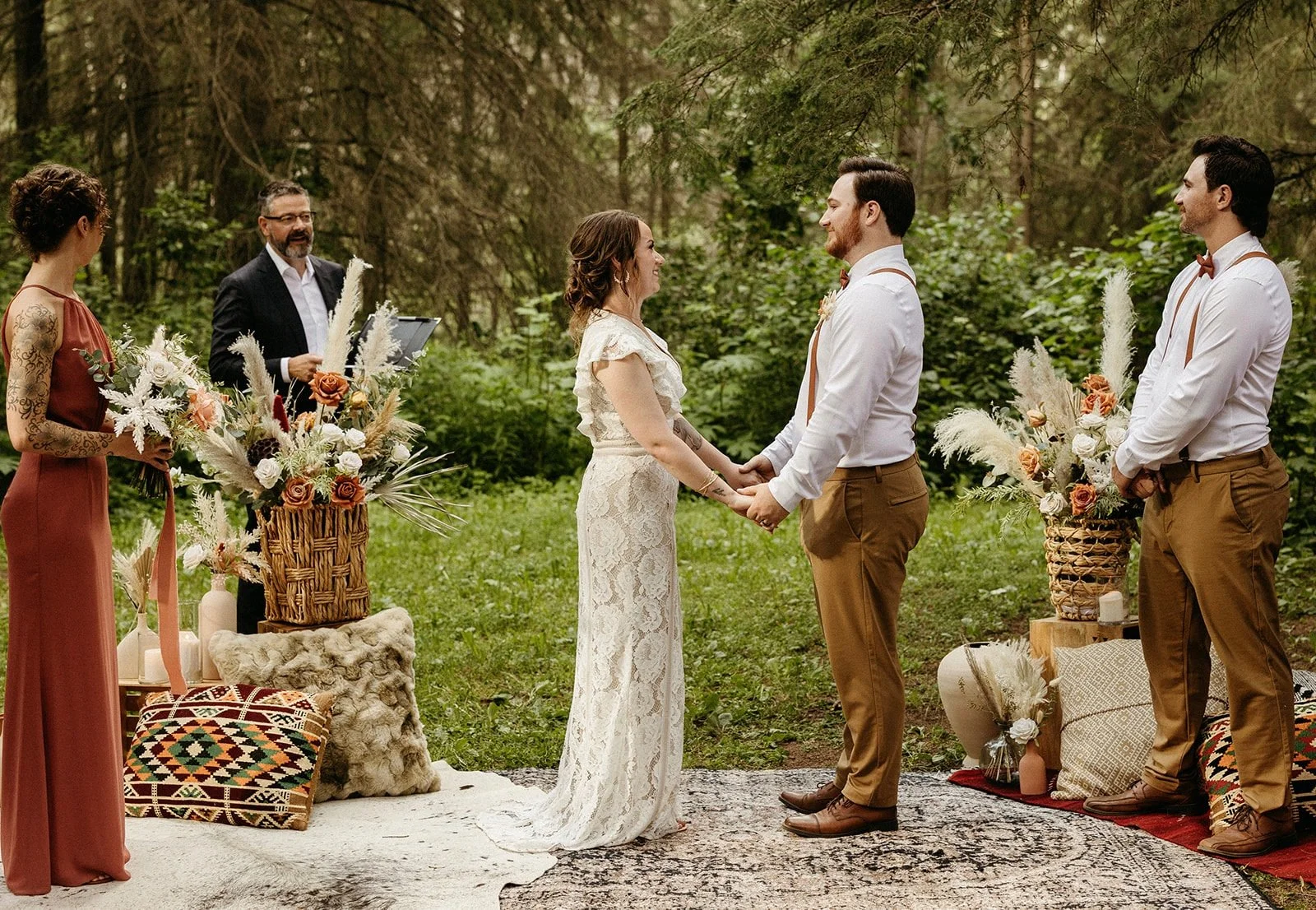 Bride and groom exchanging heartfelt vows in a serene forest setting, with stunning floral arrangements and close friends witnessing their special moment, embodying boho elegance and intimacy.