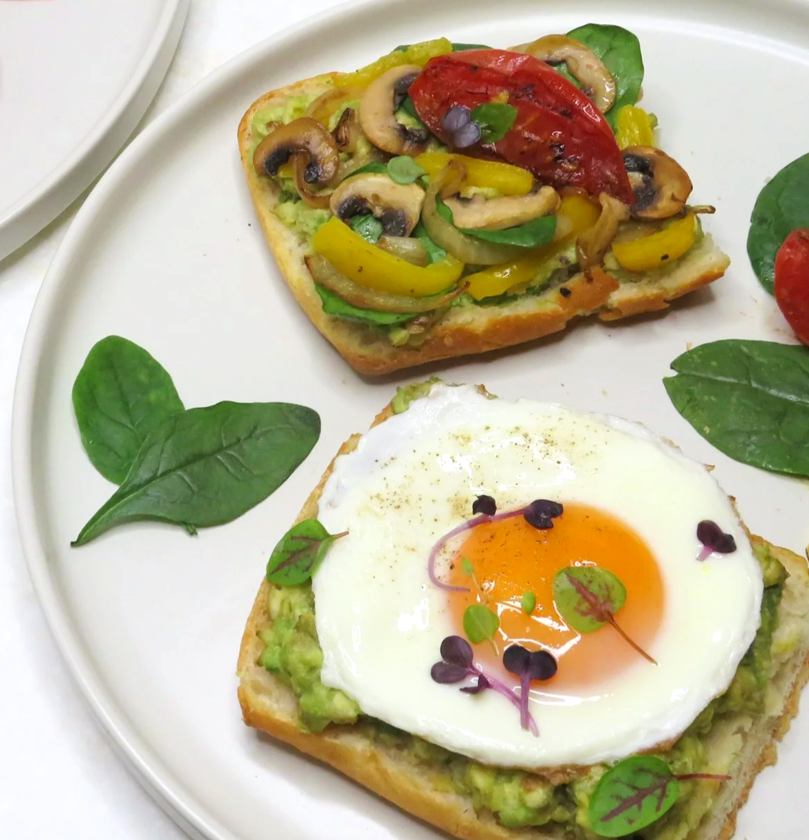Sunny side up egg with sauteed vegetables on avocado toast