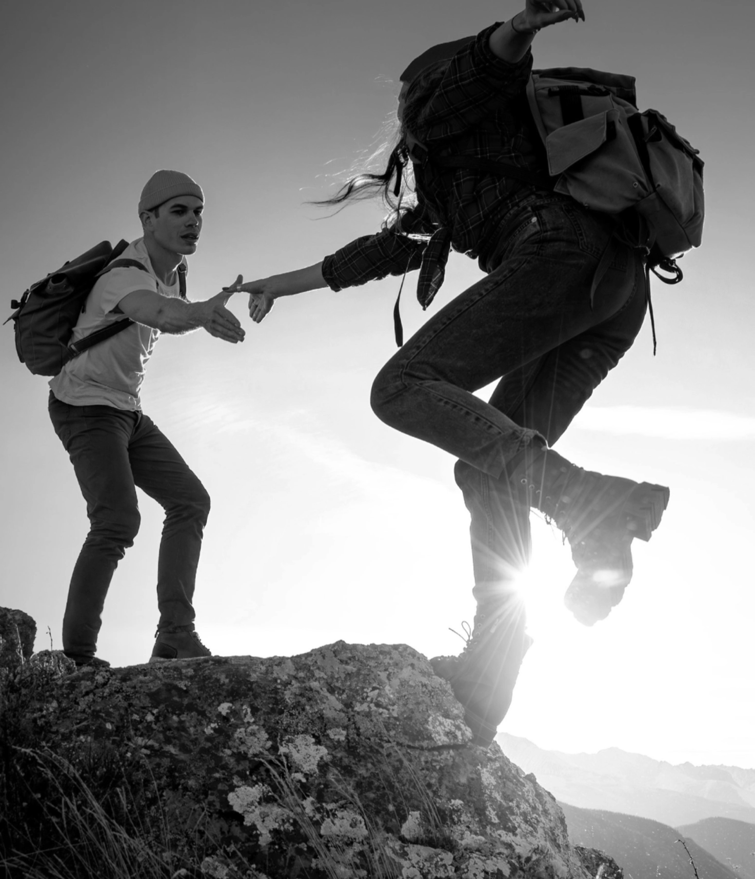 Climbers - man reaching out to help woman