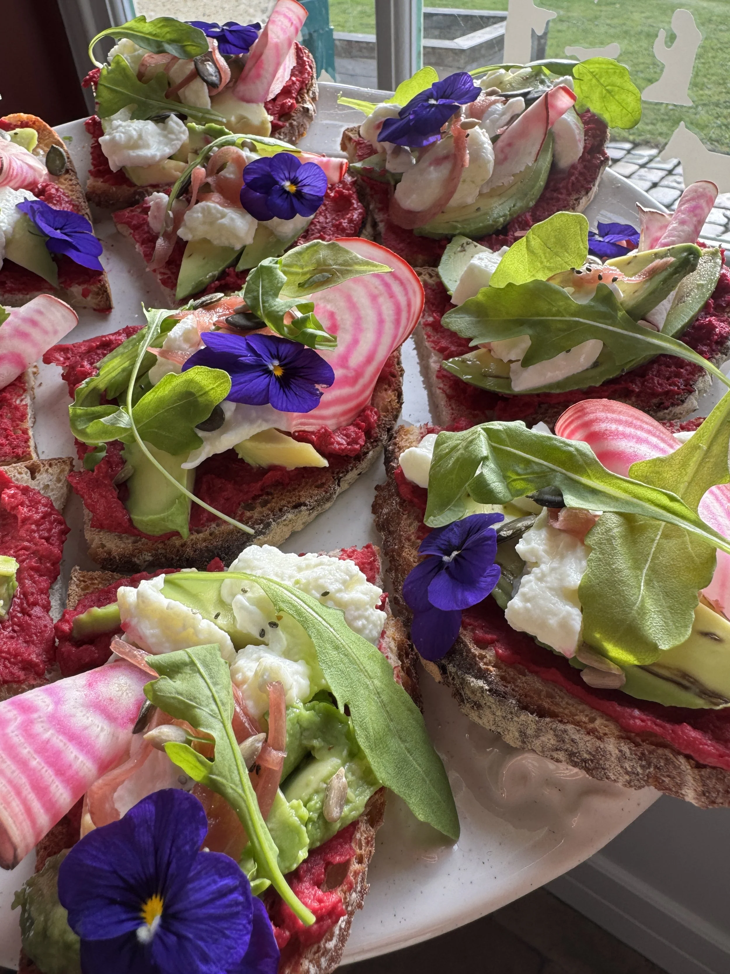 tartine à base de houmous de betterave verdure crudités et fleurs