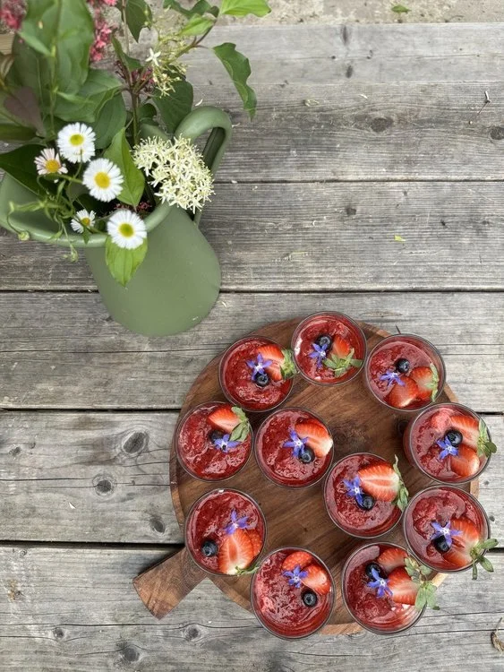 Plateau de pudding de chia et compotée de fraise sur table en bois et bouquet de fleurs