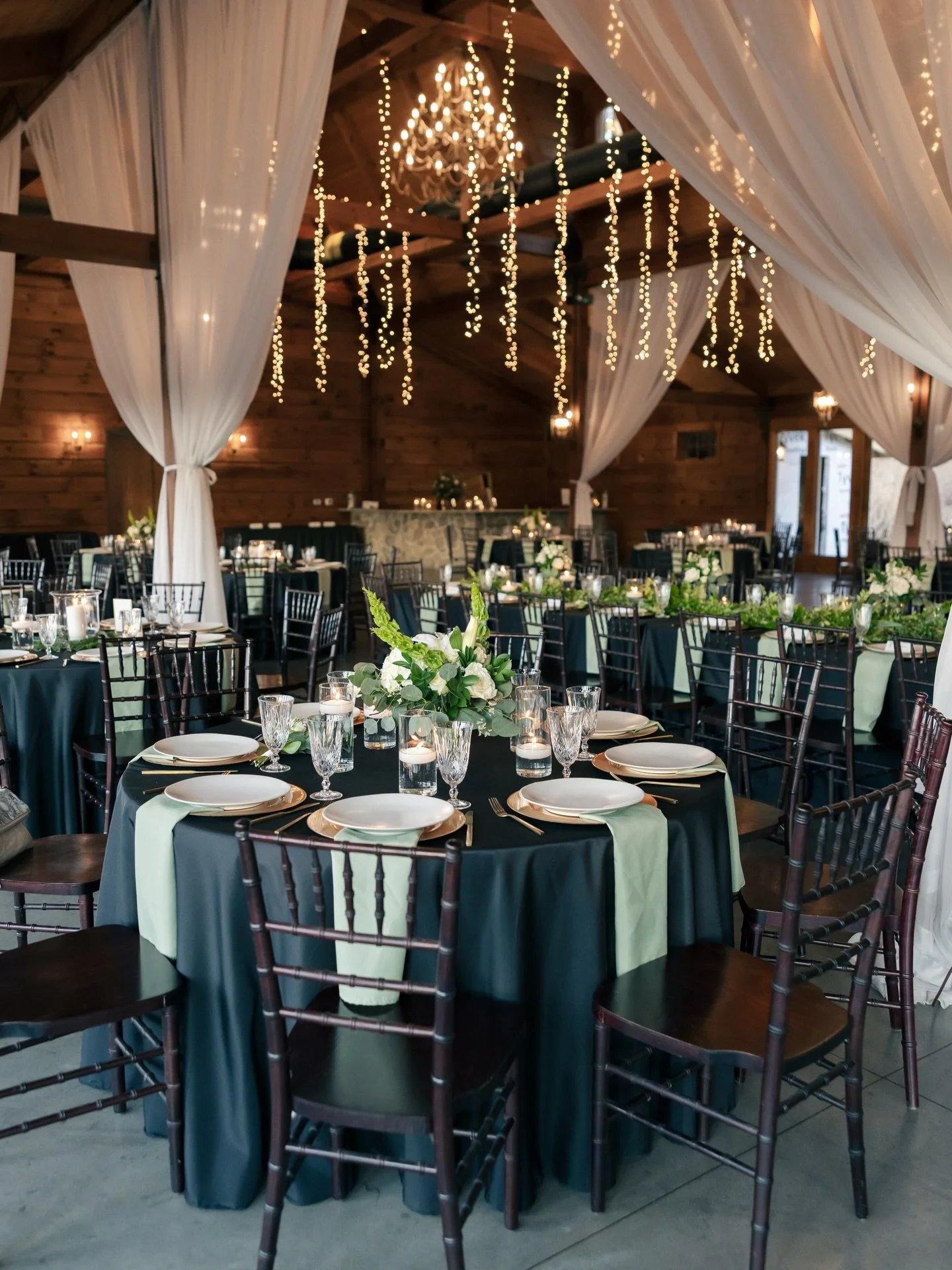 Candlelight flickering on black linens, white florals in full bloom and sage green details tying it all together.✨ A winter reception to remember for M+D. 🤍🌿

Planner: @alysonjean_events
Venue: @pavilion_at_carriage_farm
Photographer: @kyliesimspho