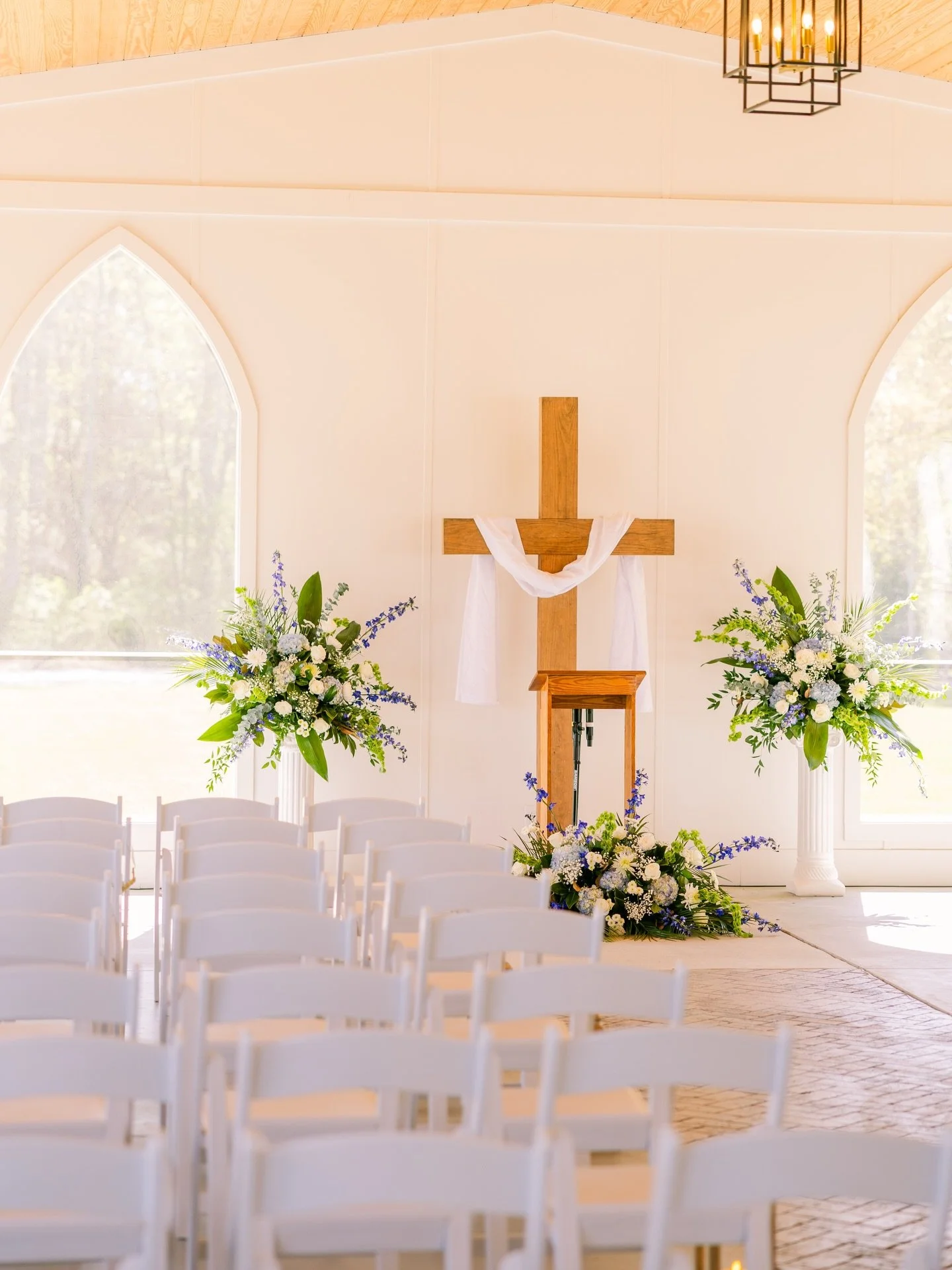 From &ldquo;I do&rdquo; beneath an open-air chapel with a cross draped in flowing white fabric, surrounded by soft blue and white florals, to a reception filled with thoughtful touches &mdash;patterned linens, gold chargers, and delicate blue and whi
