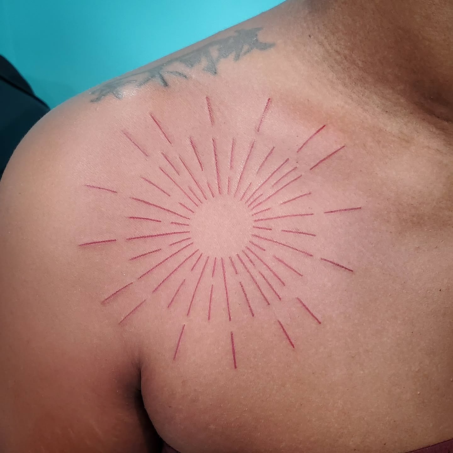 Precision meets simplicity in this #fineline #redink #sunray shoulder piece &gt;&gt;&gt; clean, crisp, and absolutely glowing ☀️❤️

Artist: @the_matt_tatter 
.
.
.
#legacytattoovi #YouArePartOfOurLegacy #redtattoo #linework #suntattoo #usvi #virginis
