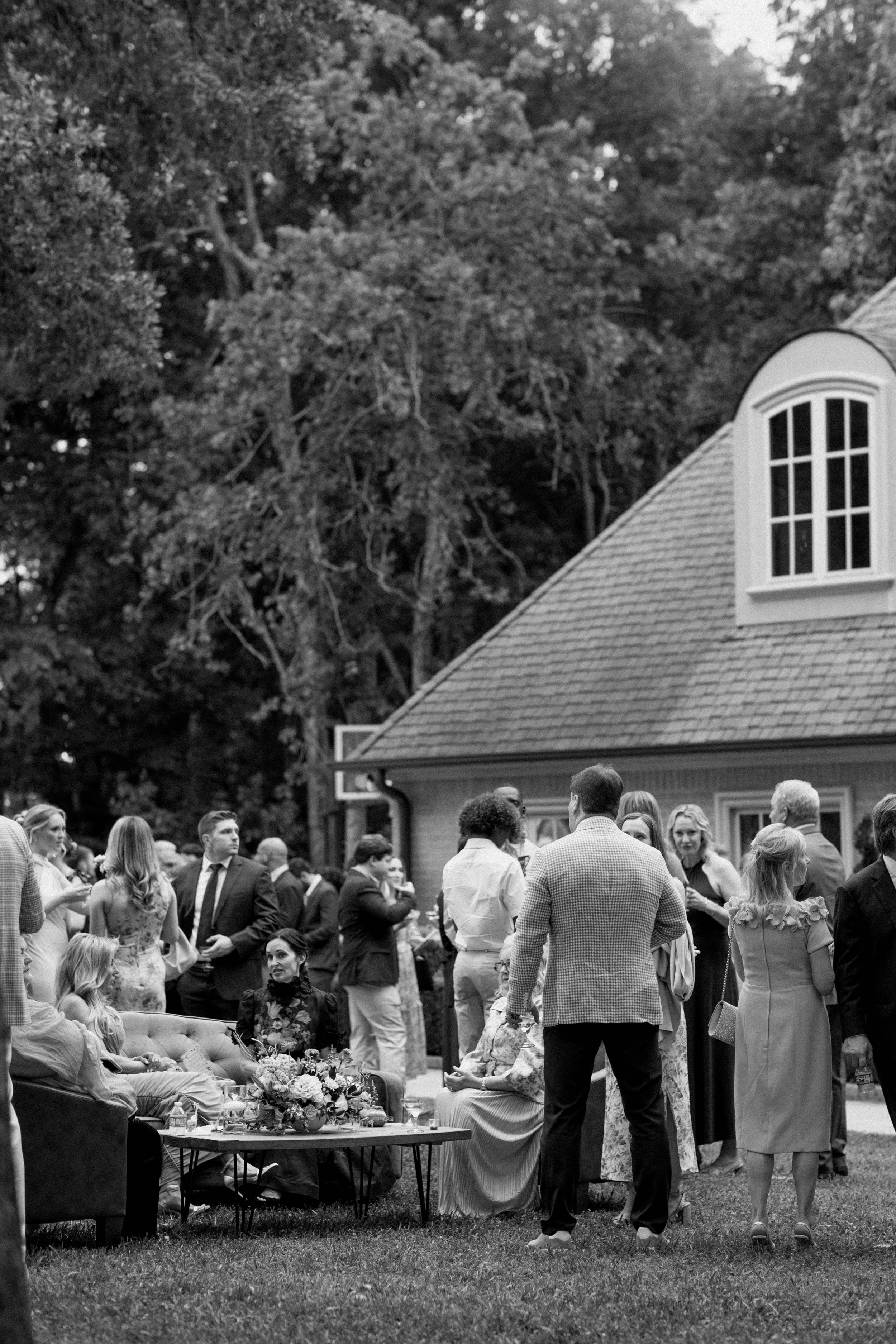 black and white photo - reception mingling and the ambiance of an elevated backyard Estate Wedding in East Texas.