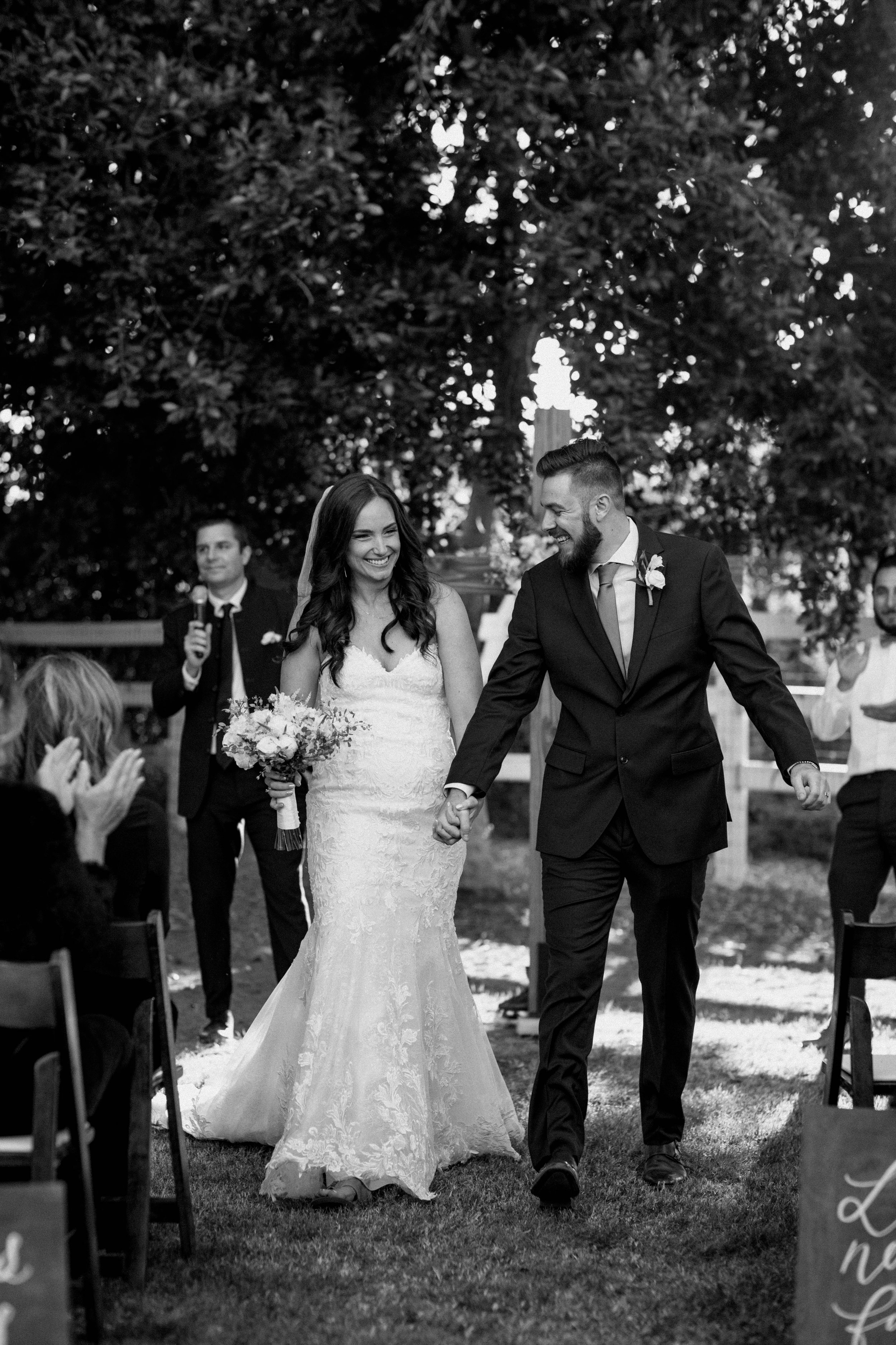 Bride and groom celebrating down the aisle after just saying "I do", unfiltered wedding joy - nostalgic moments meant to be cherished for years to come.