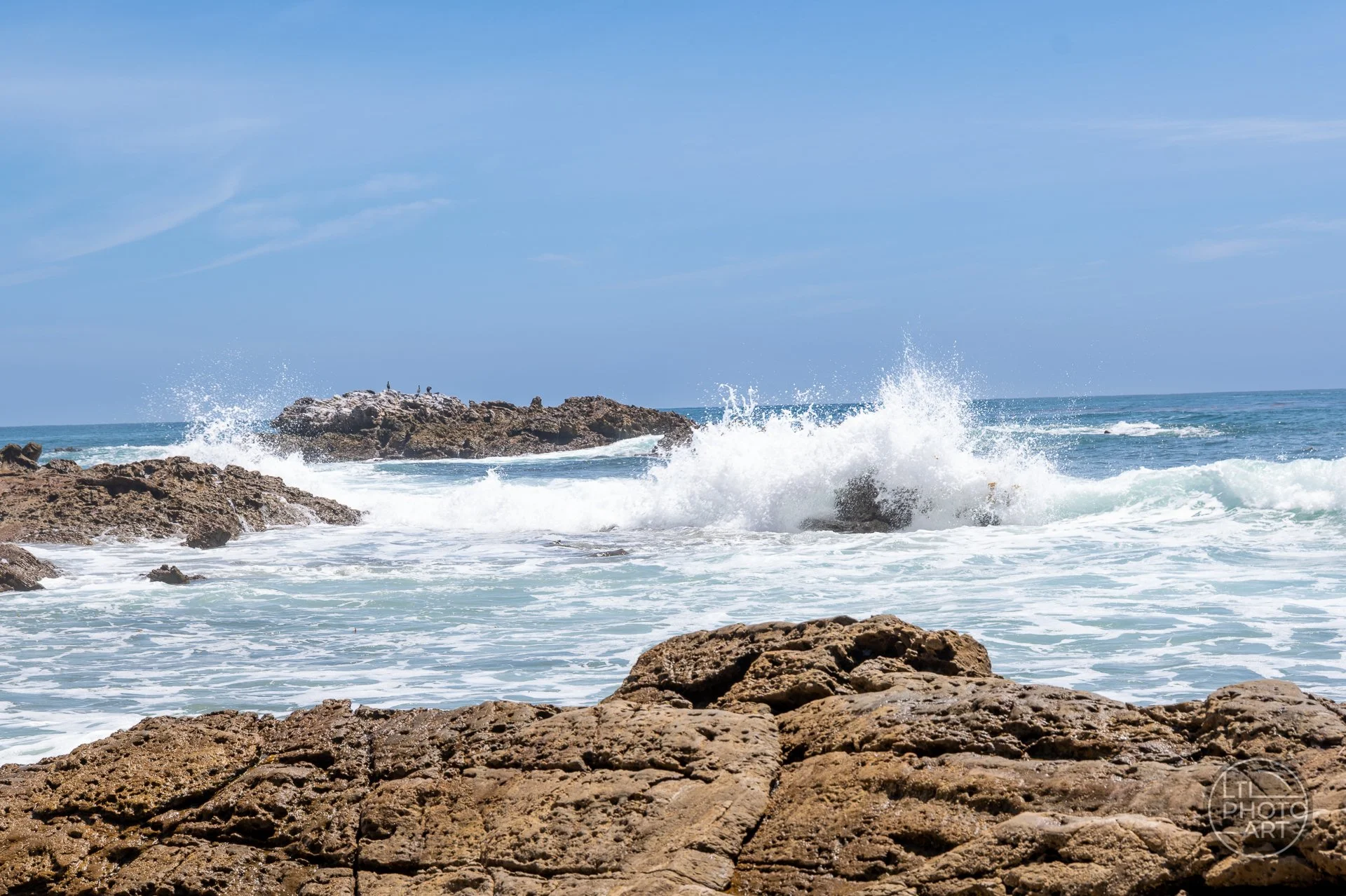 Moving down to sea level at Bird Rock changes the photograph completely, bringing rock texture, wave movement, ocean spray, and coastal energy into the foreground.